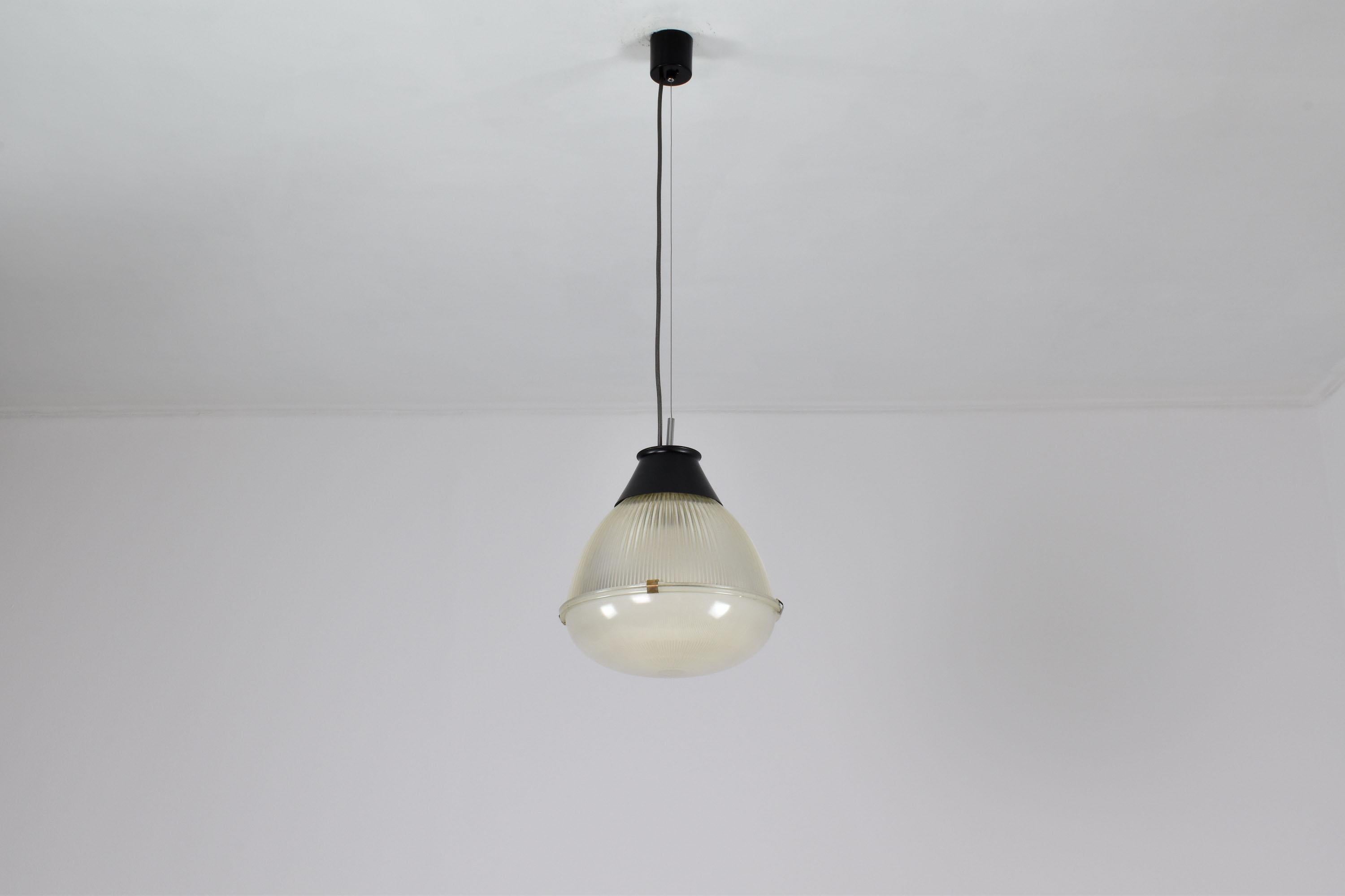A beautiful Italian collectible pendant light designed by the notable Ignazio Gardella for Azucena in the 1960s. This modern design is highlighted by its industrial-inspired black aluminum structure and two glass shades with brass clips. 
Italy.