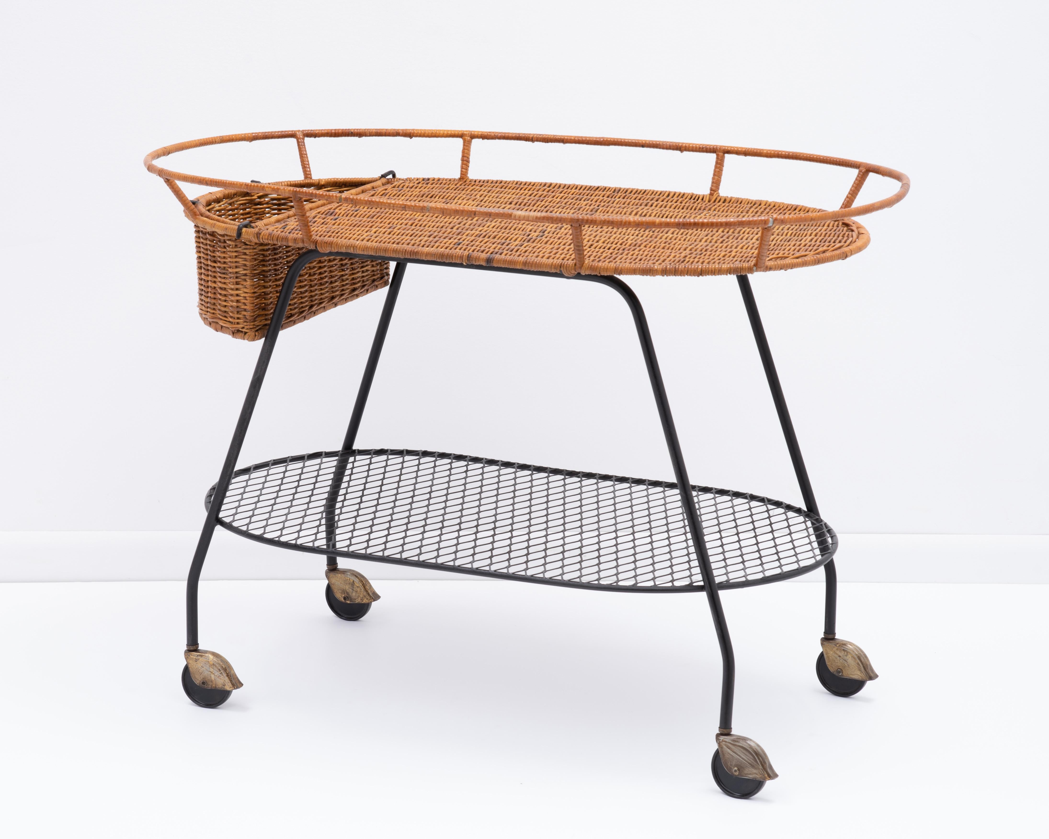 Mid-Century Modern vintage wicker and wrought iron rolling bar cart attributed to Arthur Umanoff. The two-tiered serving or tea trolley features a woven rattan top with a removable basket, a black iron lower tier, and a wrought iron frame fitted