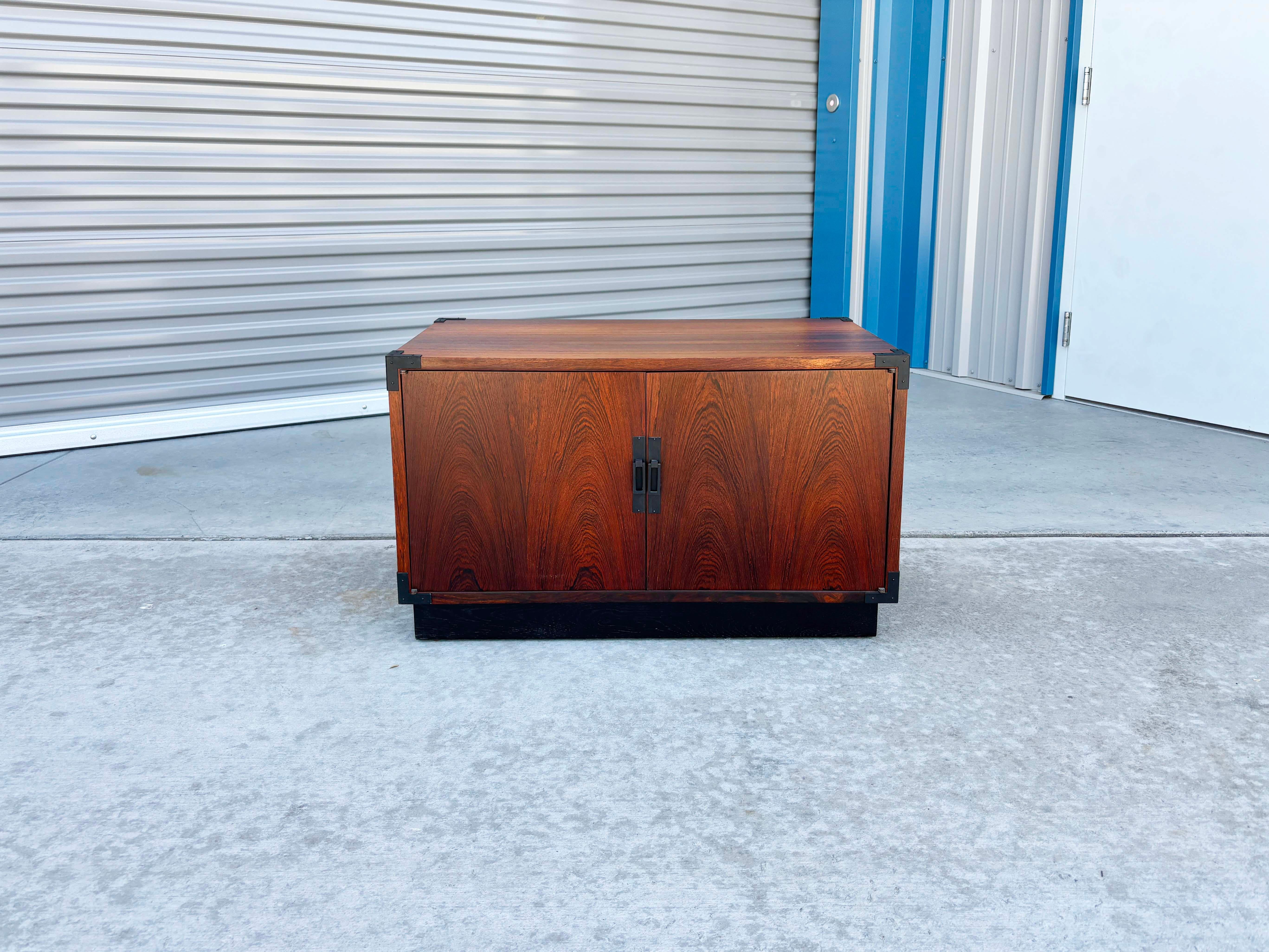 Welcome to Mid-Century NoHo

[Mid Century Rosewood Two-Door Cabinet]

This mid-century two-door cabinet, designed and crafted in the United States in the 1960s, showcases a beautiful rosewood frame. It features sleek black metal handles on the