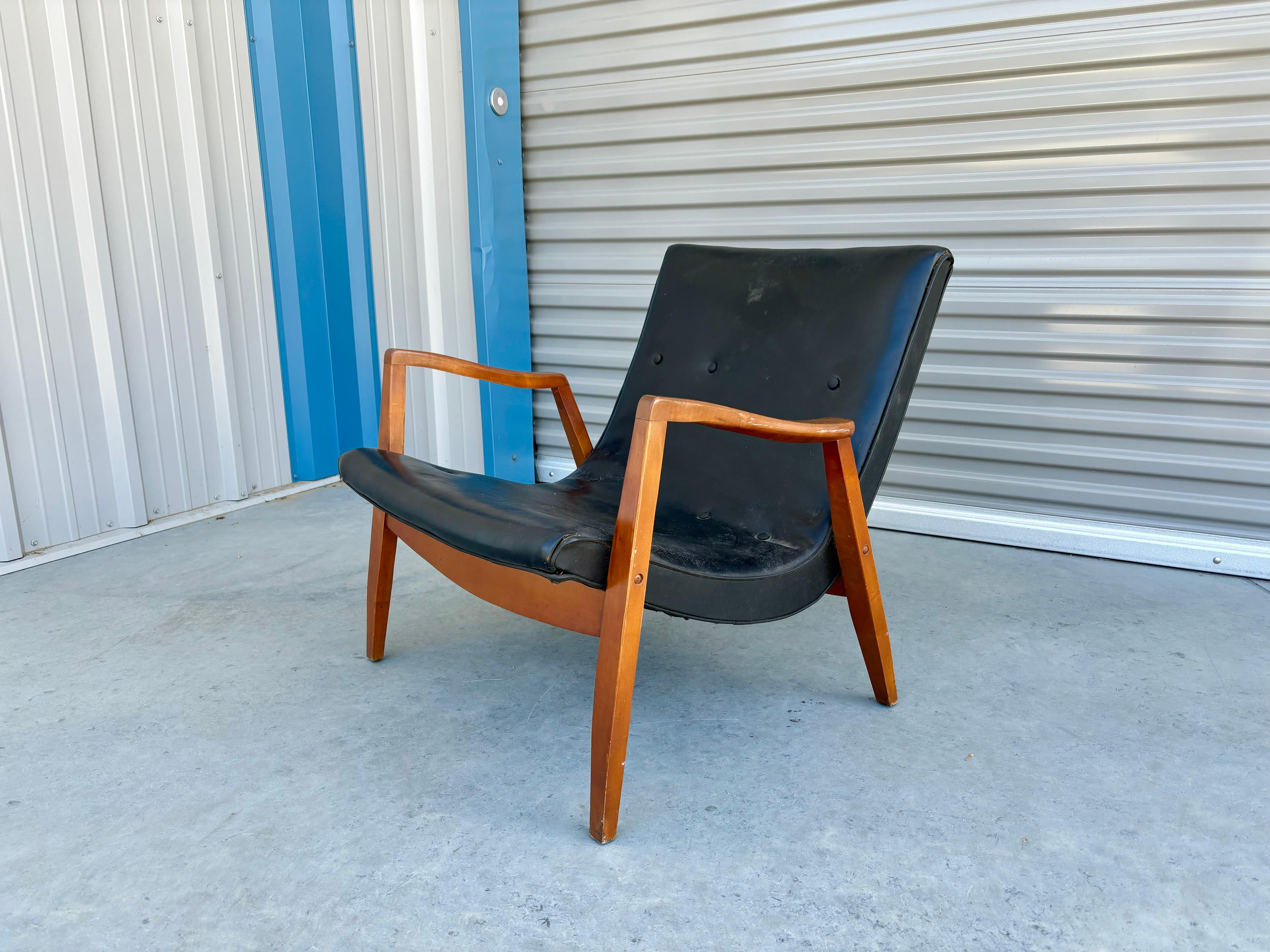 This exquisite mid-century scoop lounge chair is a true masterpiece of furniture design, designed and manufactured by Milo Baughman in the United States during the 1960s. The chair features a sleek and sophisticated black leather upholstery that