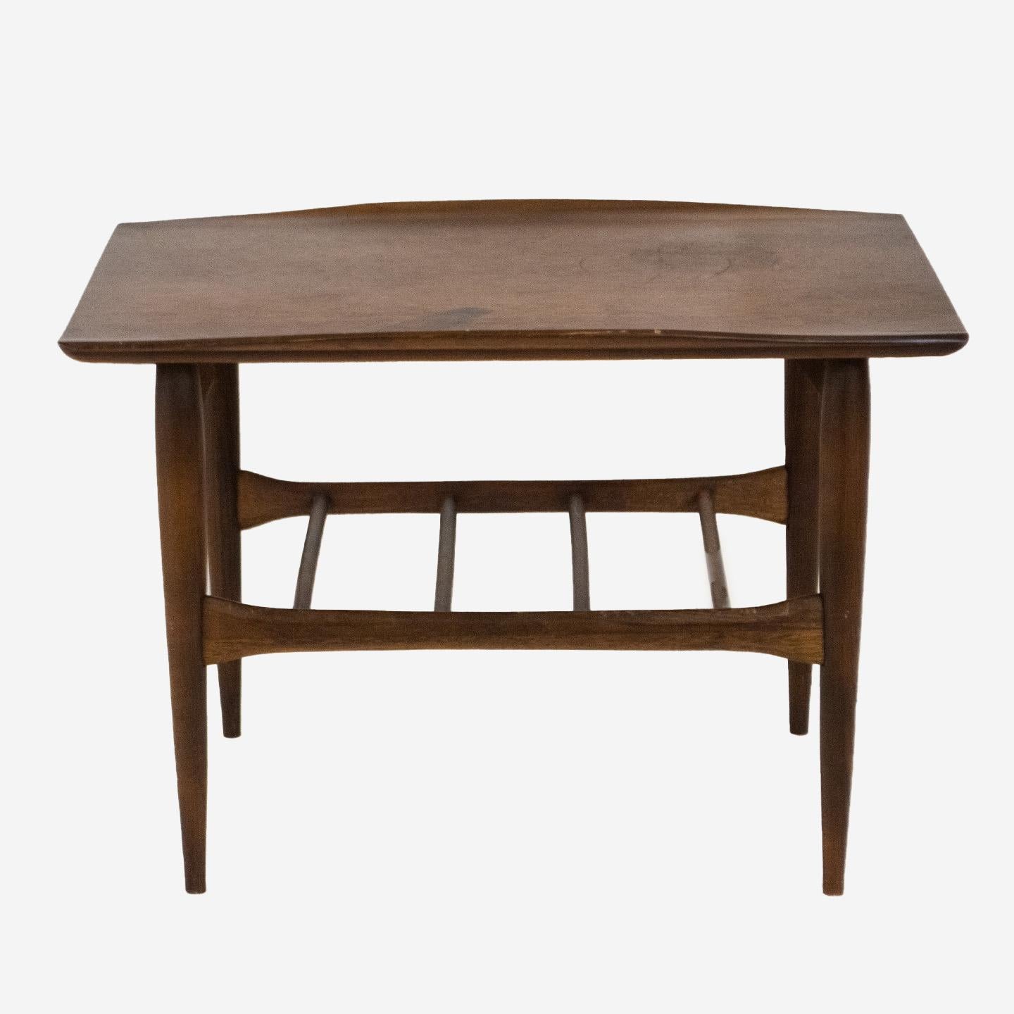 Mid-Century Modern walnut coffee table by Bassett Furniture Company, circa 1965. Surfboard style table with distinctive raised edges — typical of Danish modern production — but American produced. It's been constructed with solid walnut with gorgeous