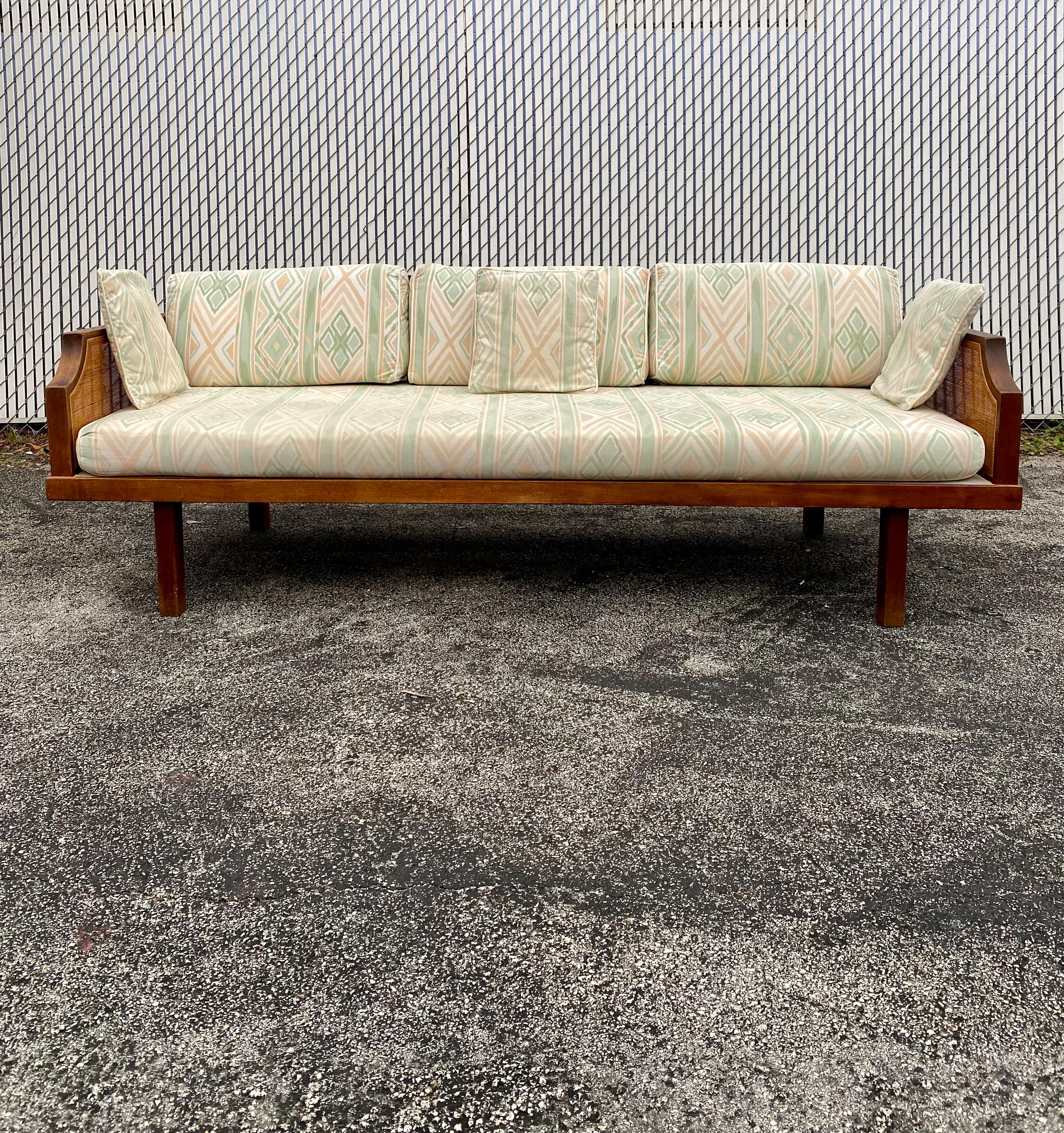 This rare mid-century rattan cane daybed/sofa is statement piece which is also extremely comfortable and packed with personality! This sofa is in great shape for its age. The support straps are also original and in fantastic condition. Just look at
