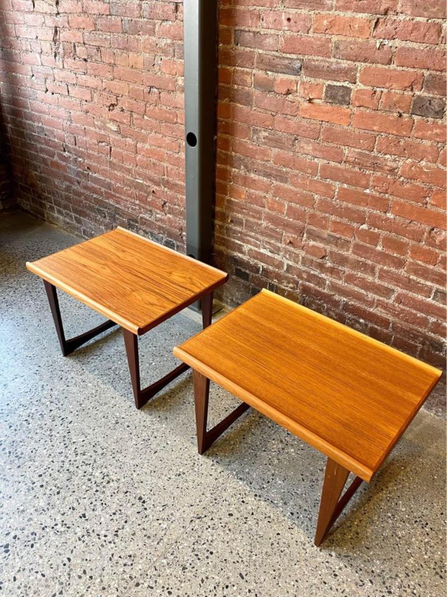 Introducing another stunning addition to our showroom: this captivating pair of end tables crafted from teak and Afromosia wood in the 1960s. With their sleek sled leg construction and delicately sculpted lips along each side of the surface, these