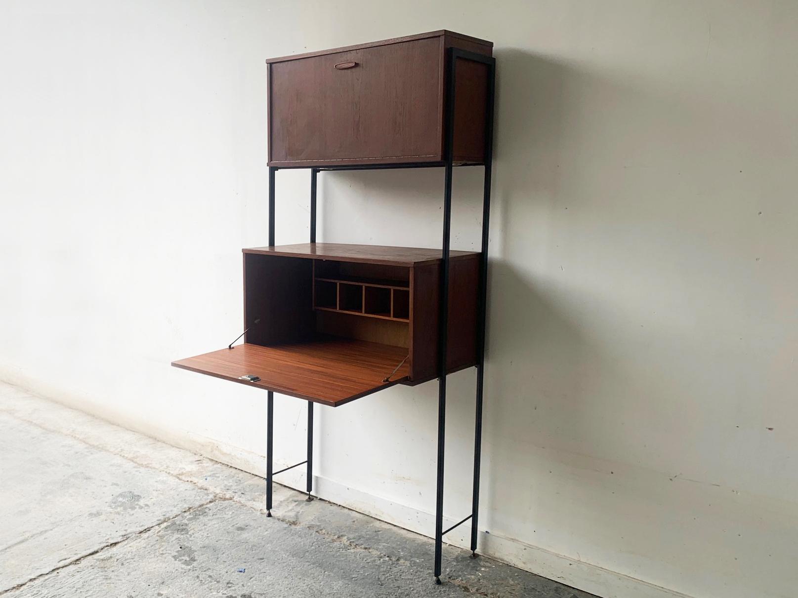 A mid century modular free standing shelving/storage unit manufactured by respected manufacturer ‘Avalon’ in the UK.

The cabinets are teak and and teak veneer with their original metal cross supports and black metal uprights. The two units  can be