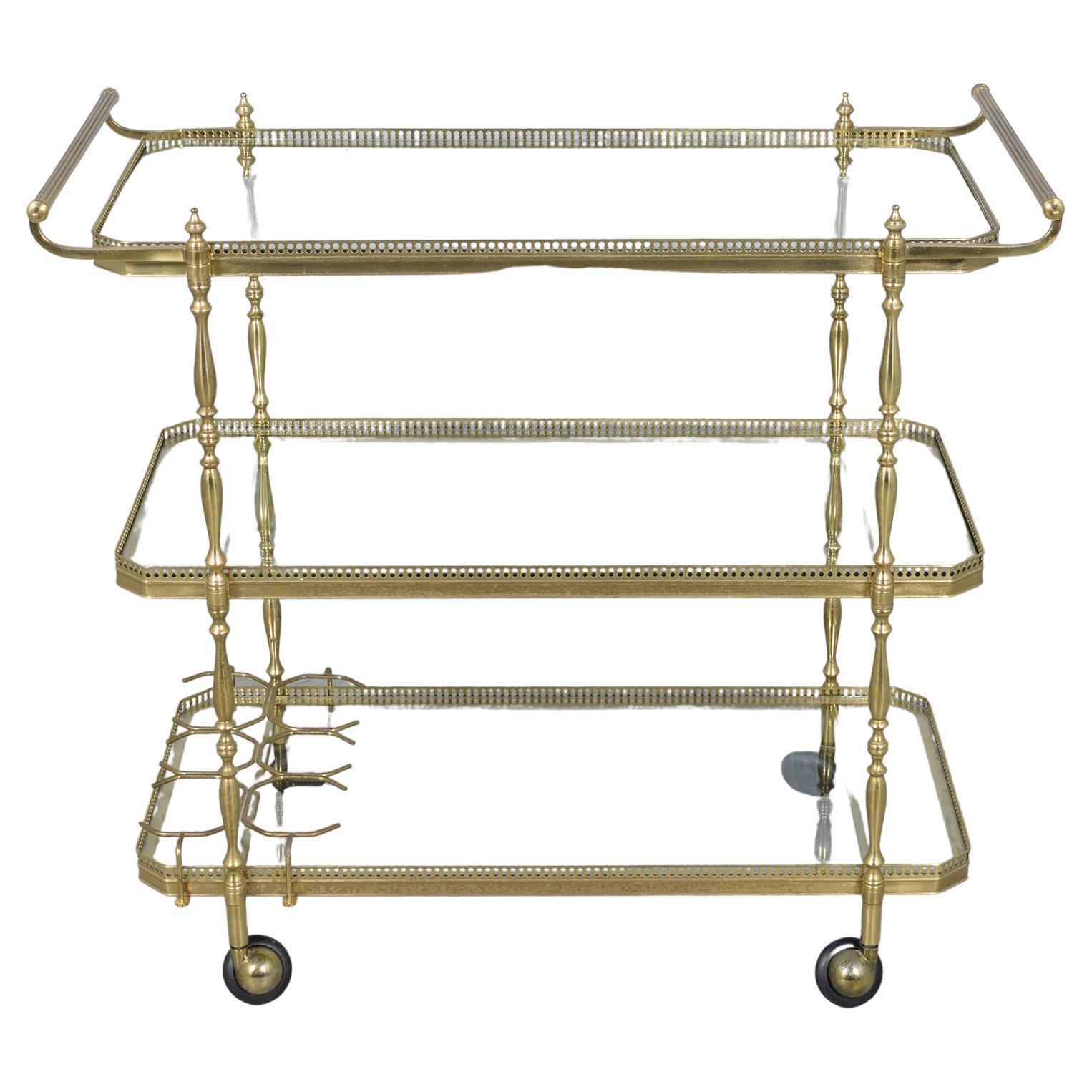 Step into the sophisticated world of the 1960s with our stunning bar cart, a perfect blend of brass and glass. Expertly restored in-house by our team of seasoned craftsmen, this mid-century gem shines in its pristine condition. Its lustrous original