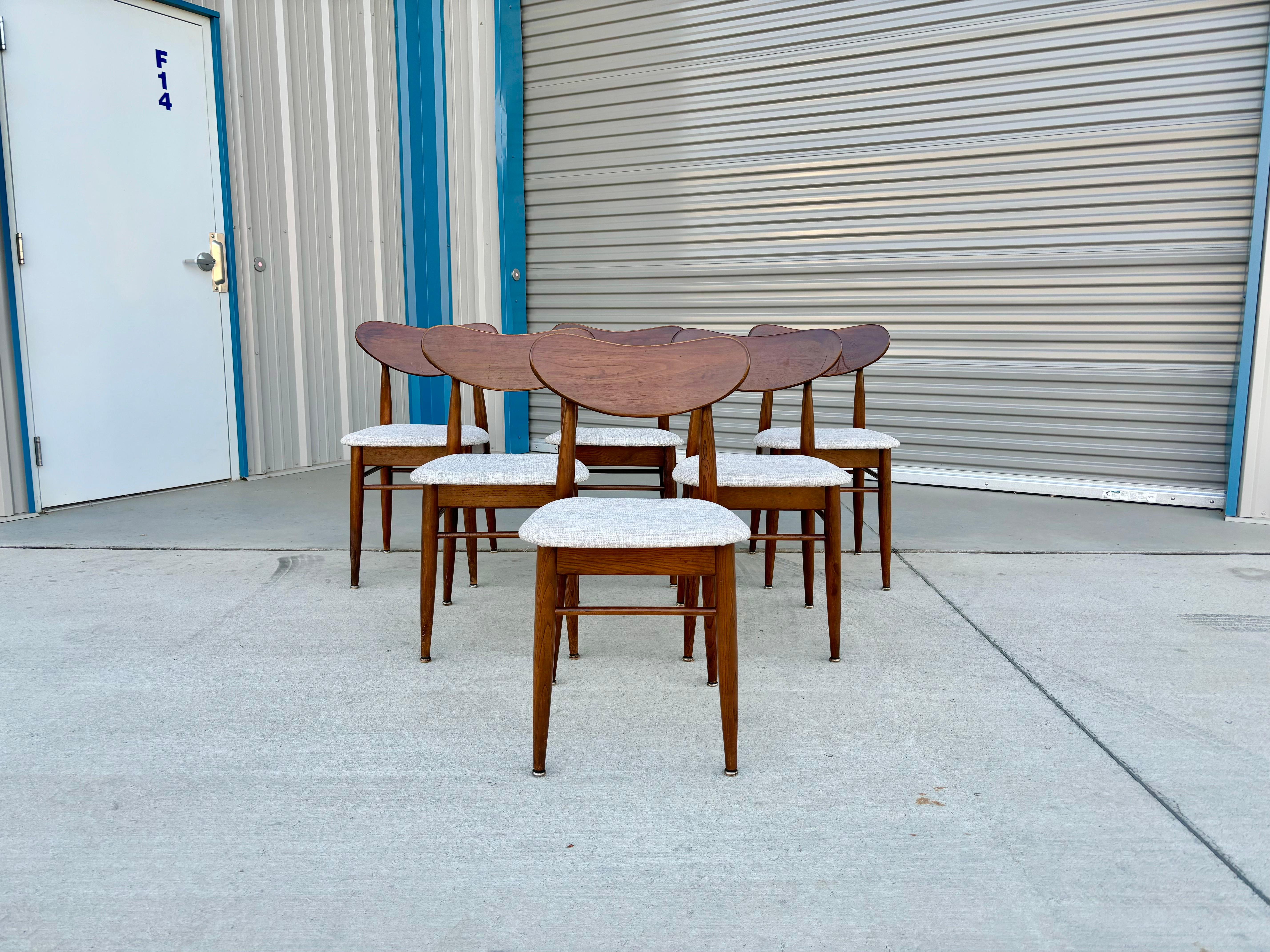 Mid-century walnut dining chairs designed and manufactured in the United States circa 1960s. These stunning dining chairs feature a walnut frame. Whether you're looking to add elegance to your dining room or want some comfortable and stylish seating