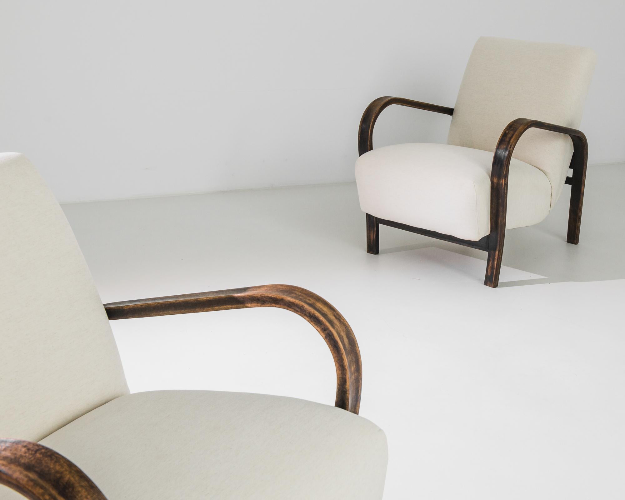 A pair of upholstered armchairs by Karel Kozelka & Antonin Kropácek, produced in Czechia circa 1960. A pair of chairs, formed from soft curves in cream and brown. This award winning design from the Czech design duo is a symphony of bentwood and