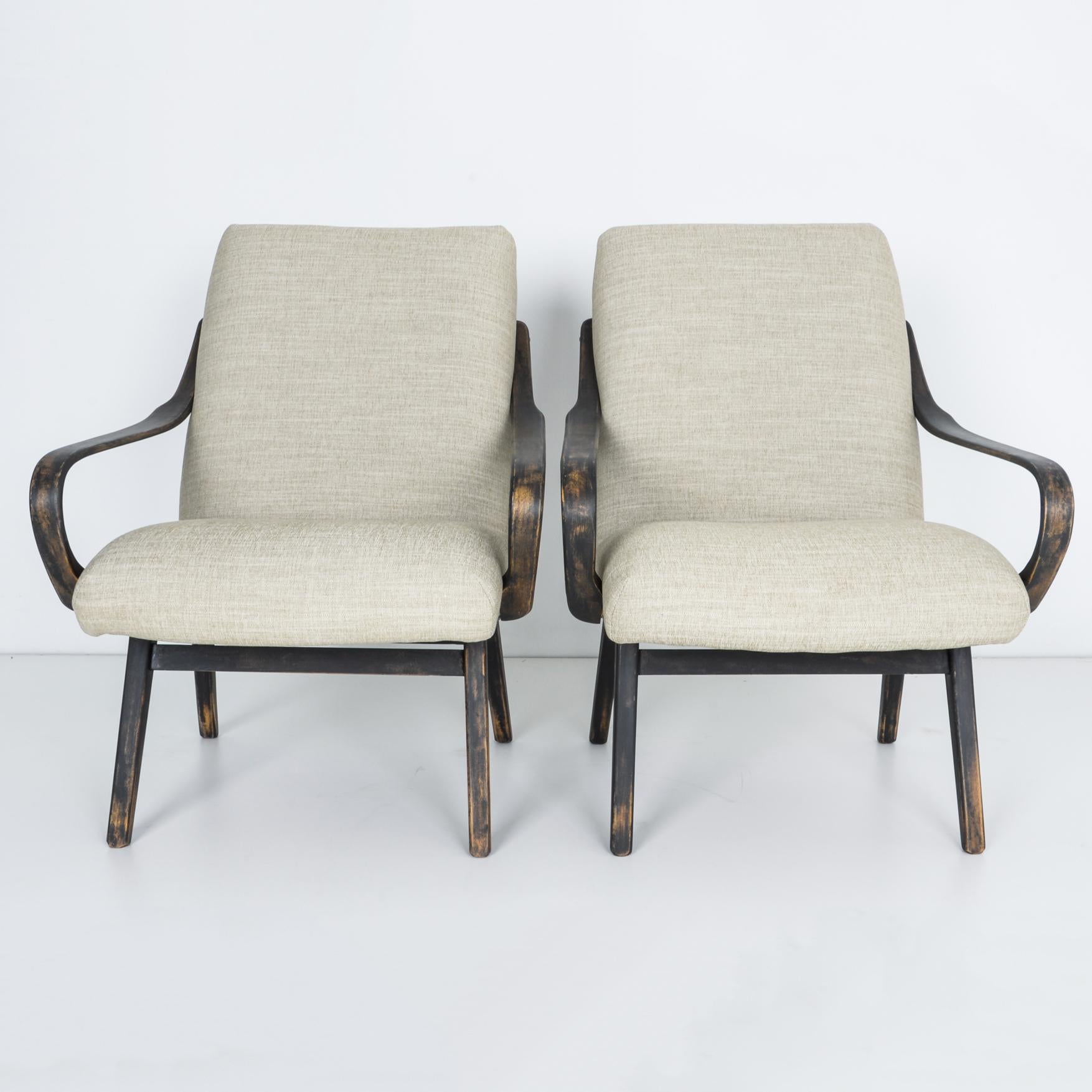 From Czech Republic circa 1950 a comfortable and stylish pair of upholstered armchairs. Made from updated rich fabric, bent arms and hardwood braces. These chairs package comfort in quality style, with a patinated finish and updated upholstery.