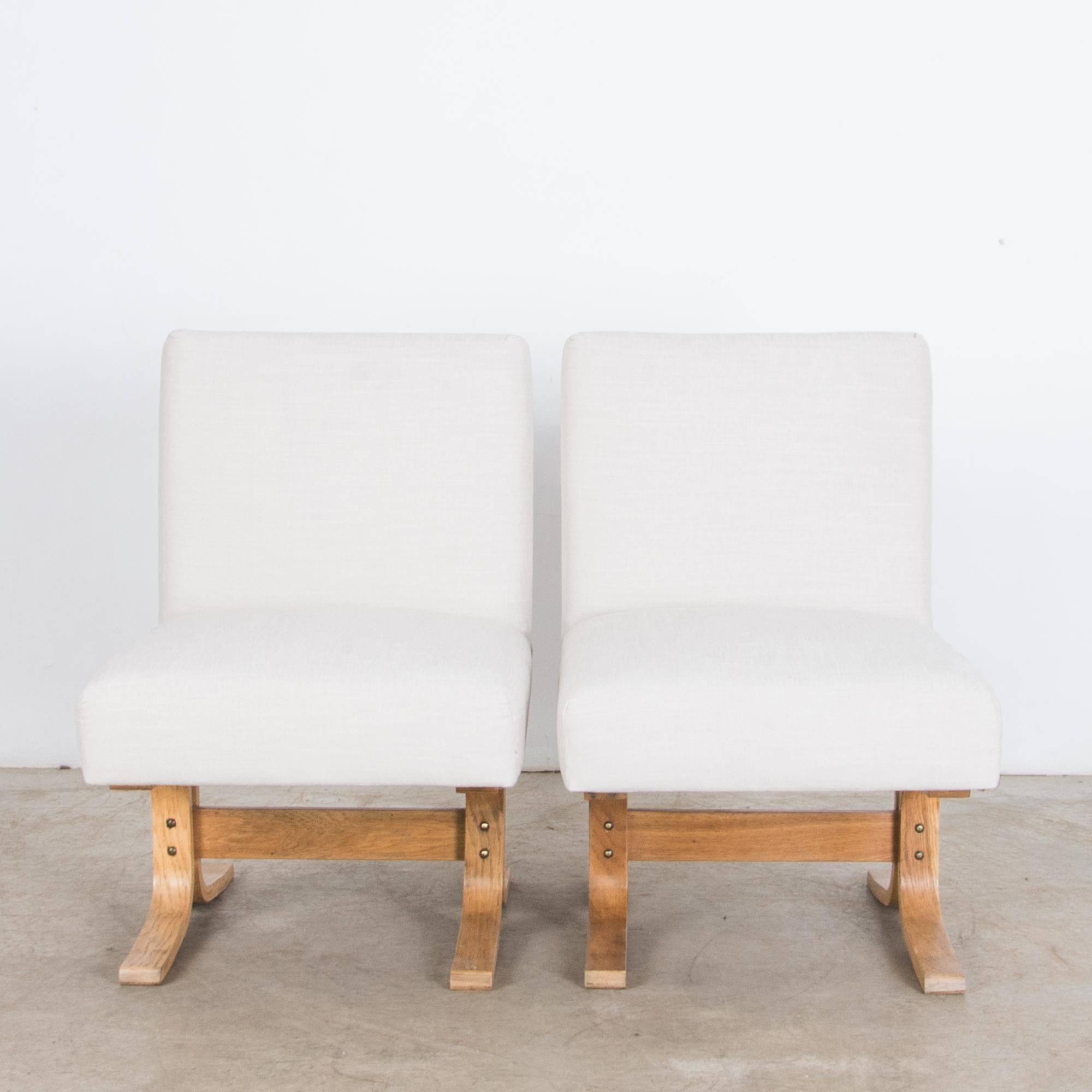 A pair of low slipper style pairs from Czech Republic, circa 1960. Composed of basic forms, a soft cushion rests on a bent hardwood frame. A contrasts of textures and colors, curves and straight lines, casual seating in typical Mid-Century Modern