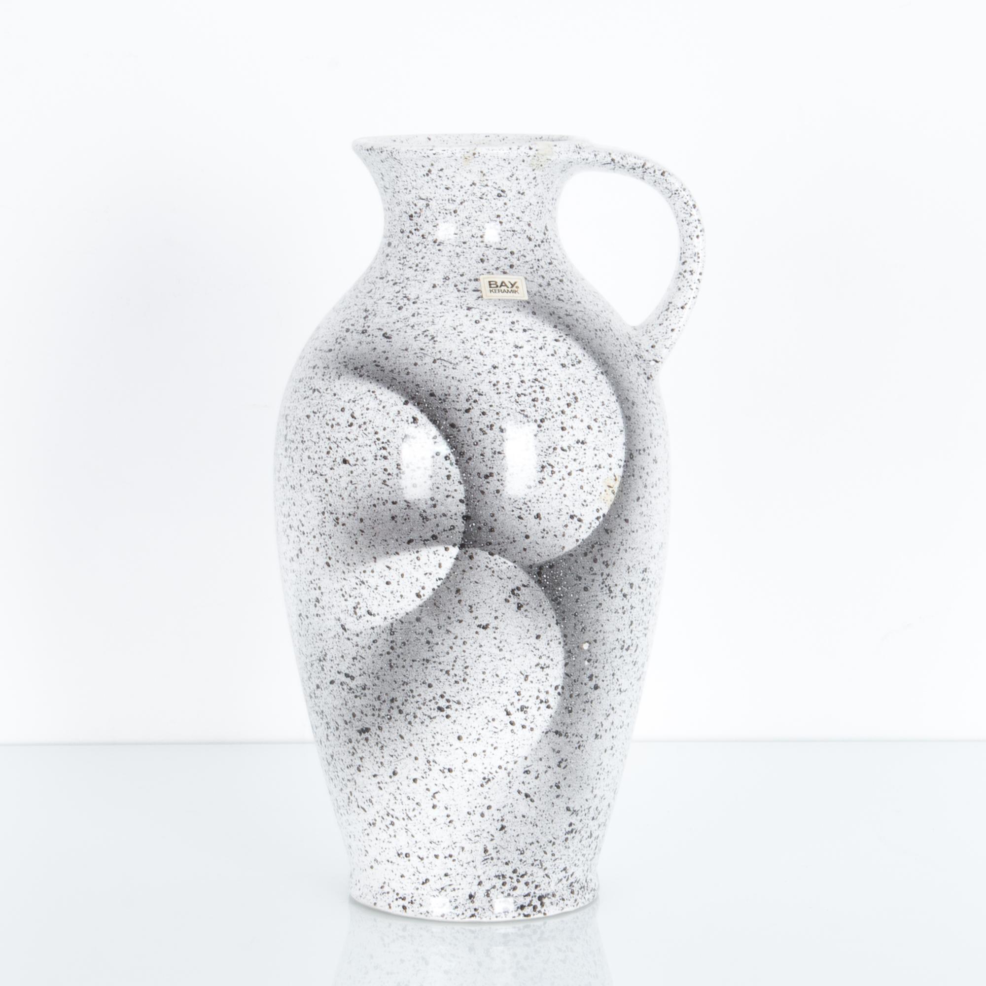 A textured vase pitcher from Germany circa 1960, features a distinctive shadowy glaze, a geometric motif in atmospheric speckled white. These characteristic mid-20th century ceramics were produced in West Germany, featuring “W. Germany