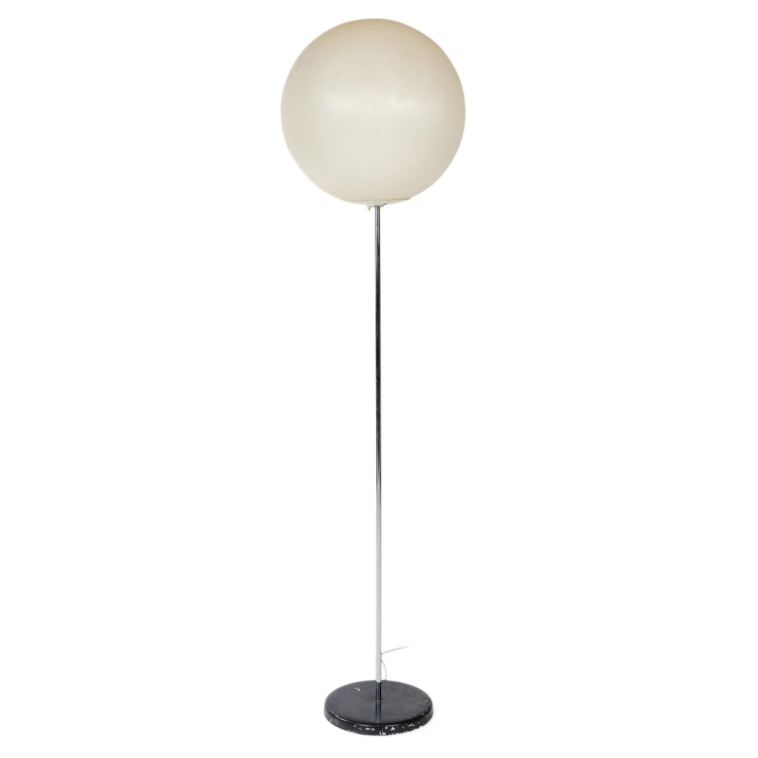 Minimalist floor lamp of geometric shapes-two circles and a straight line. Translucent plastic globe atop a vertical chrome rod threaded in to chromed metal circle painted black.