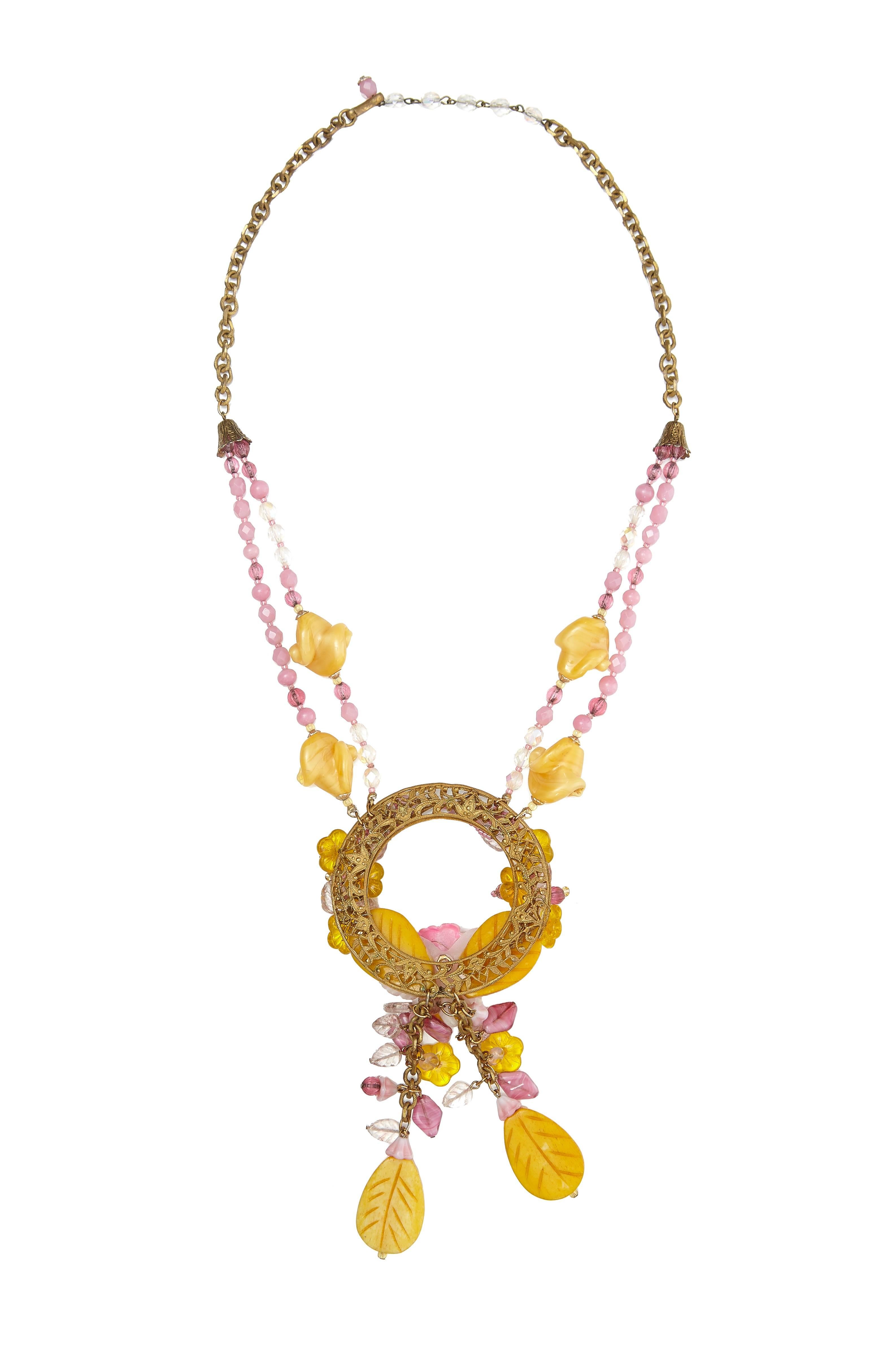 Original 1960s Miriam Haskell pink and yellow glass beaded necklace with gold tone chain.  This bold and spectacular piece features chains and beads hanging down from a large central hoop with a pretty floral design and an orchid as the central