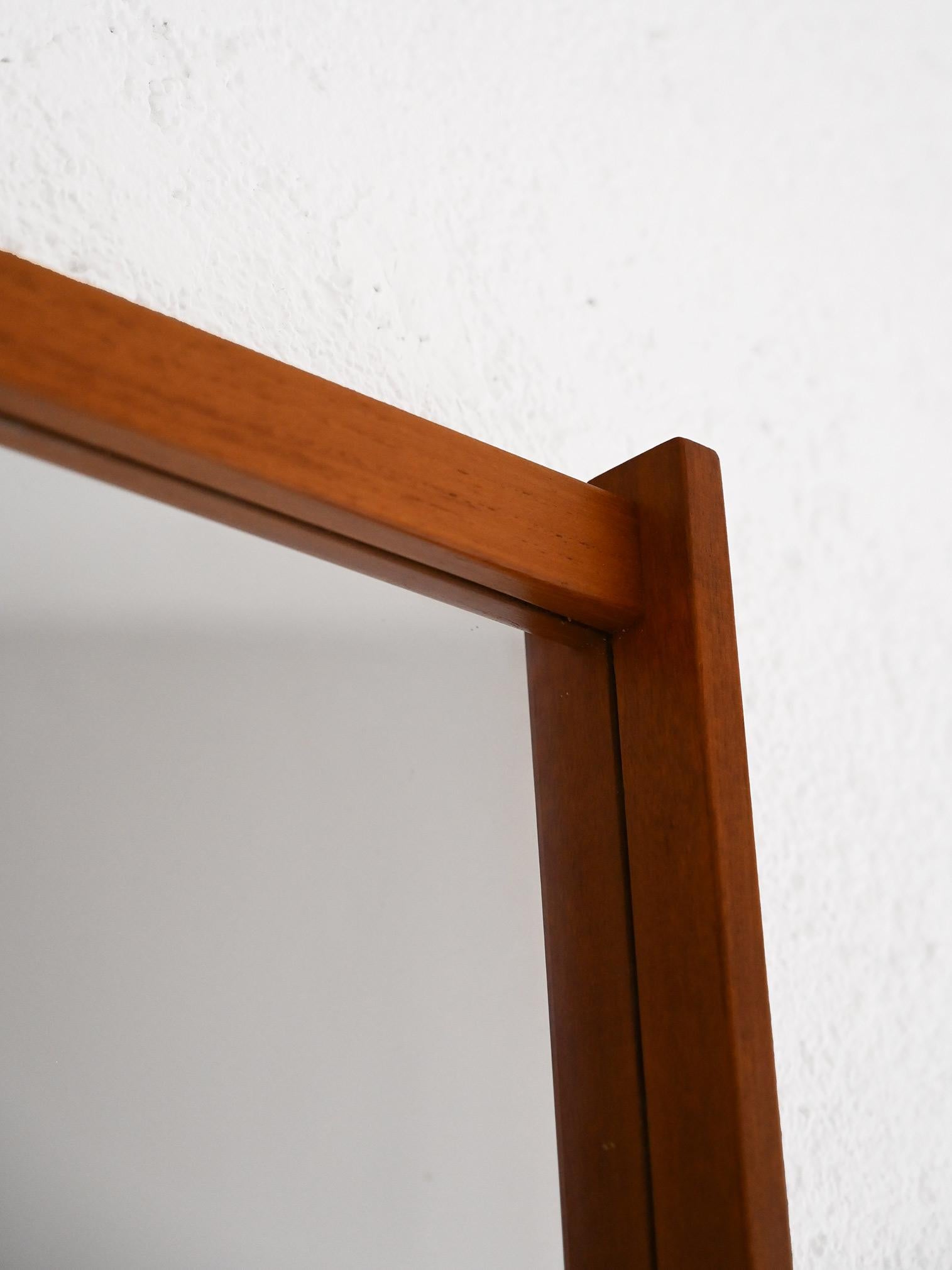 Scandinavian vintage modernism mirror.

A simple and elegant piece of furniture consisting of a rectangular teak wood frame. The long sides of the frame are protruding from the short ones, giving it an original look.
This half-figure mirror can be
