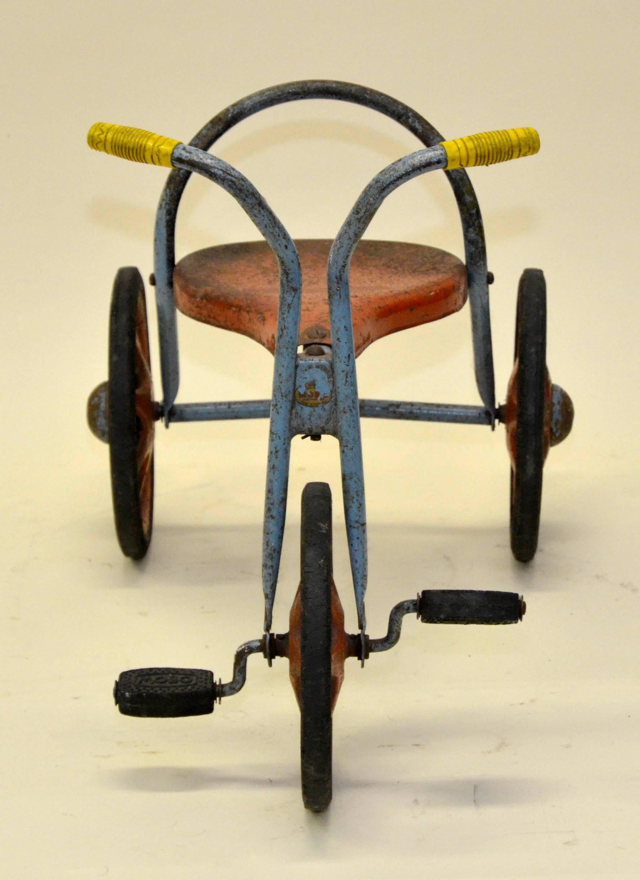 This vintage toddler's three wheeled tricycle in red, light blue and yellow color was produced by English toy manufacturer Mobo in the early 1960s.

Collector's note:

Mobo Toy's were made by D. Sebel & CO., Erith, Kent, England from 1947-1972.