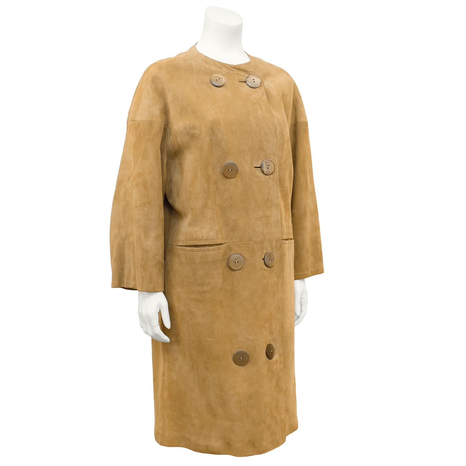 1960's Swedish made mod beige double breasted kid suede coat. Collarless with drop shoulders, large semi clear plastic buttons and horizontal slit pockets. Monochromatic top stitching and satin lining. Marked size 38. Excellent vintage condition.