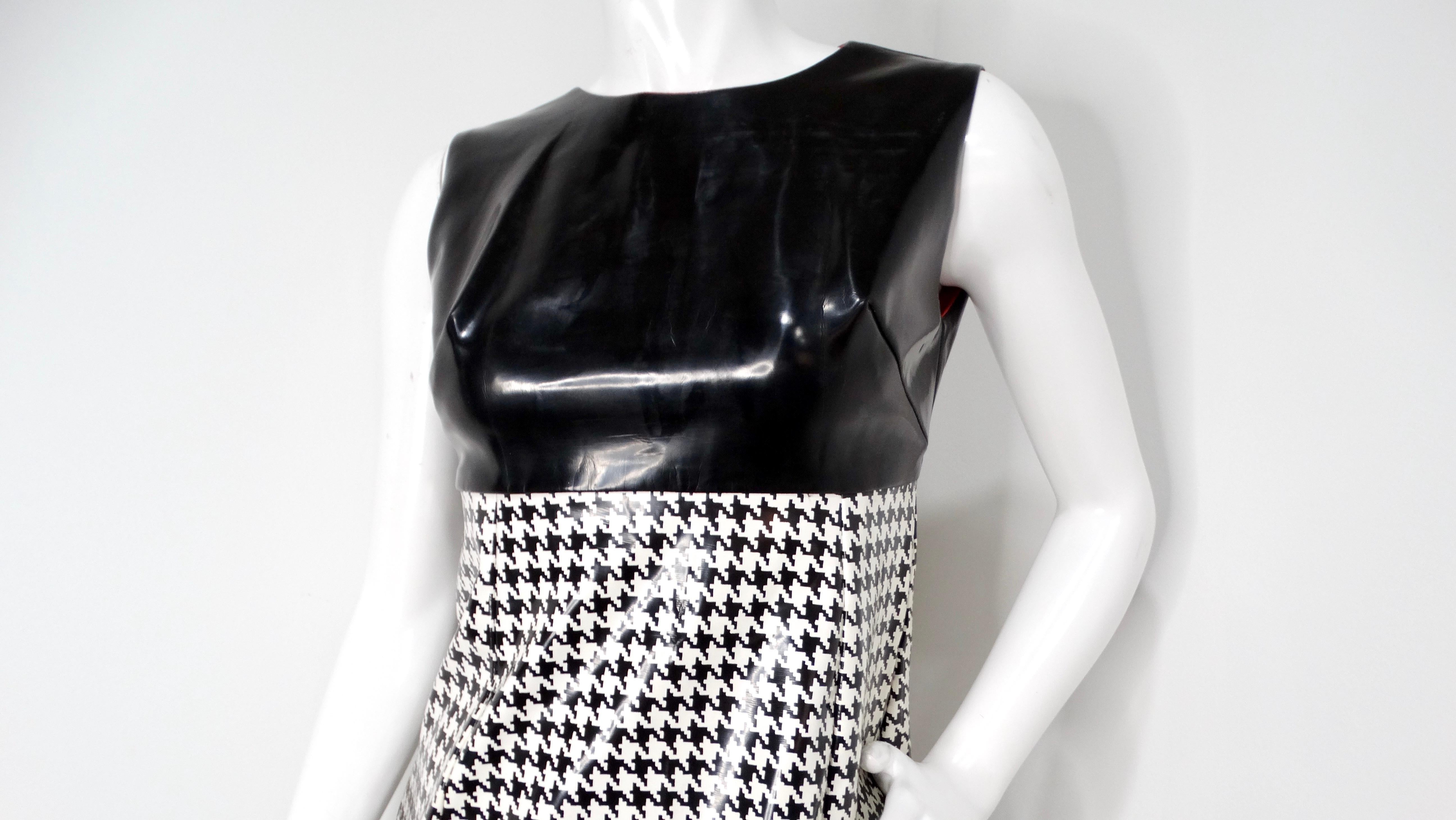 Mit diesem atemberaubenden ärmellosen Maxikleid von Mod Vinyl mit schwarzem und weißem Hahnentrittmuster lassen Sie sich vom Geist der 1960er Jahre inspirieren. Mit seinem schlichten schwarzen Oberteil, das einen schönen Kontrast zu dem kühnen