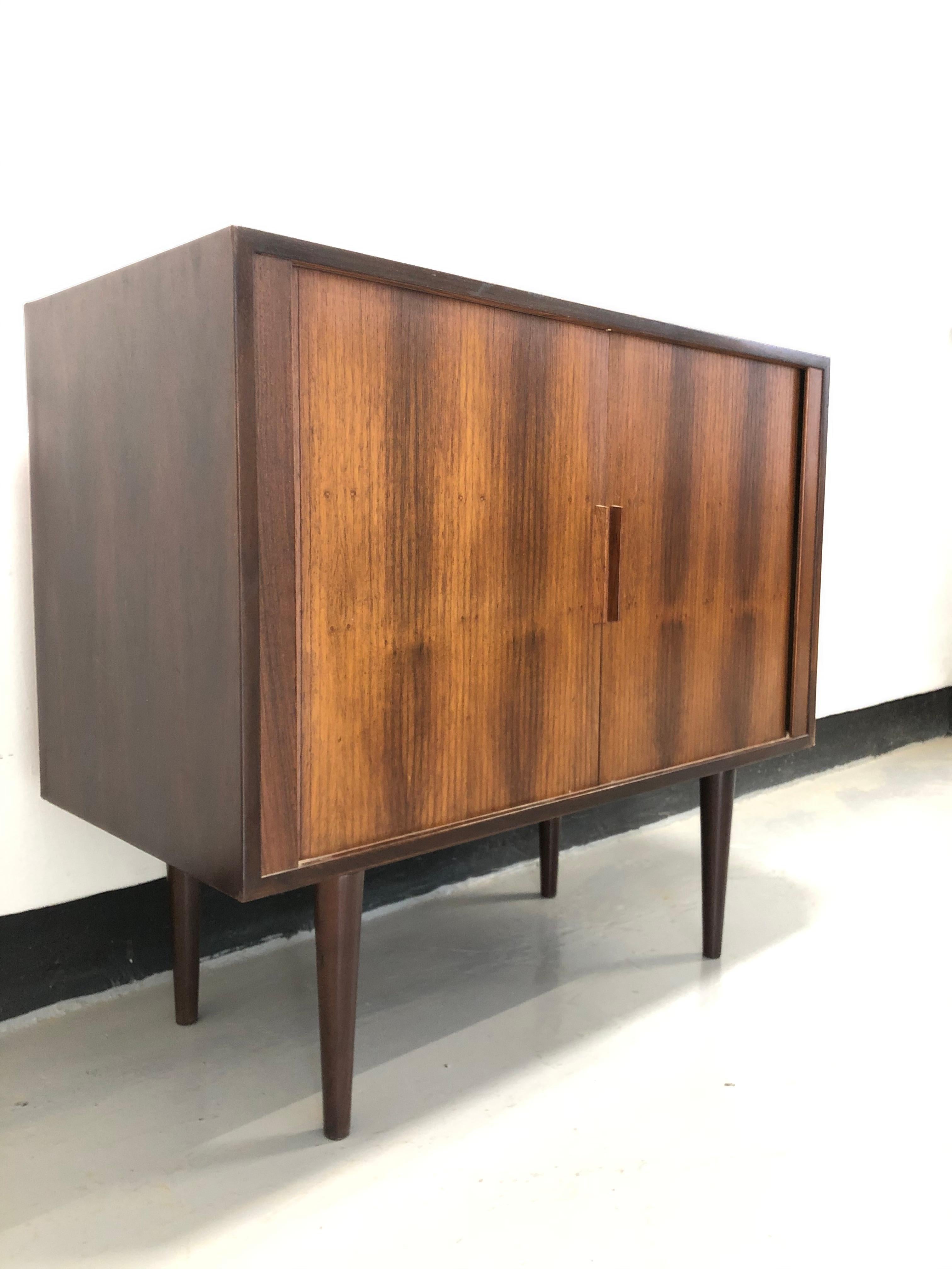 Model 42 rosewood sideboard with tambour doors and fitted interior.

Bearing maker's label to the back.