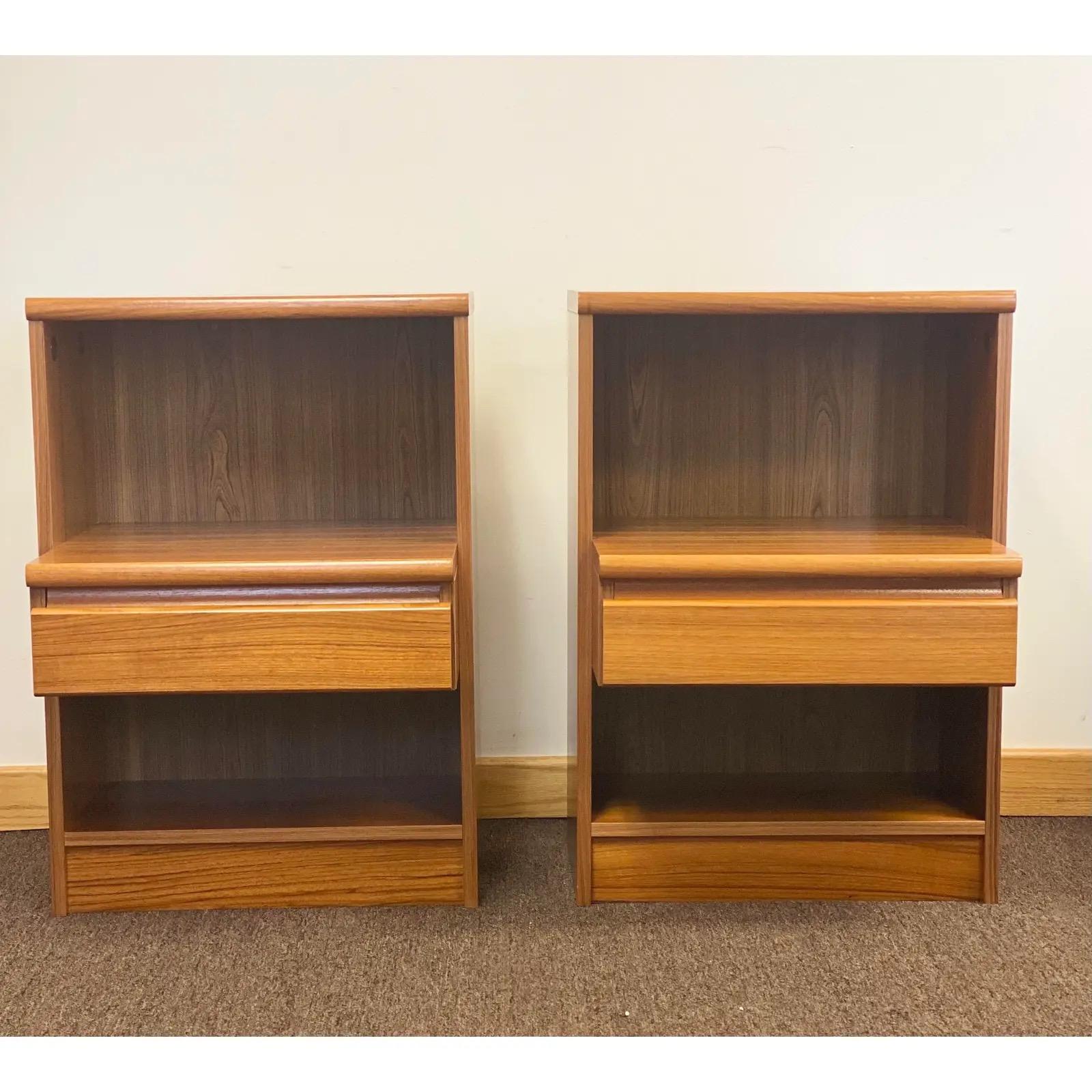 We are very pleased to offer a mid-century Danish pair of nightstands, circa the 1960s. These sturdy and heavy pieces are made of solid teak and a teak veneer backbone; hence, beautiful wood grains can be seen throughout. The nightstands feature