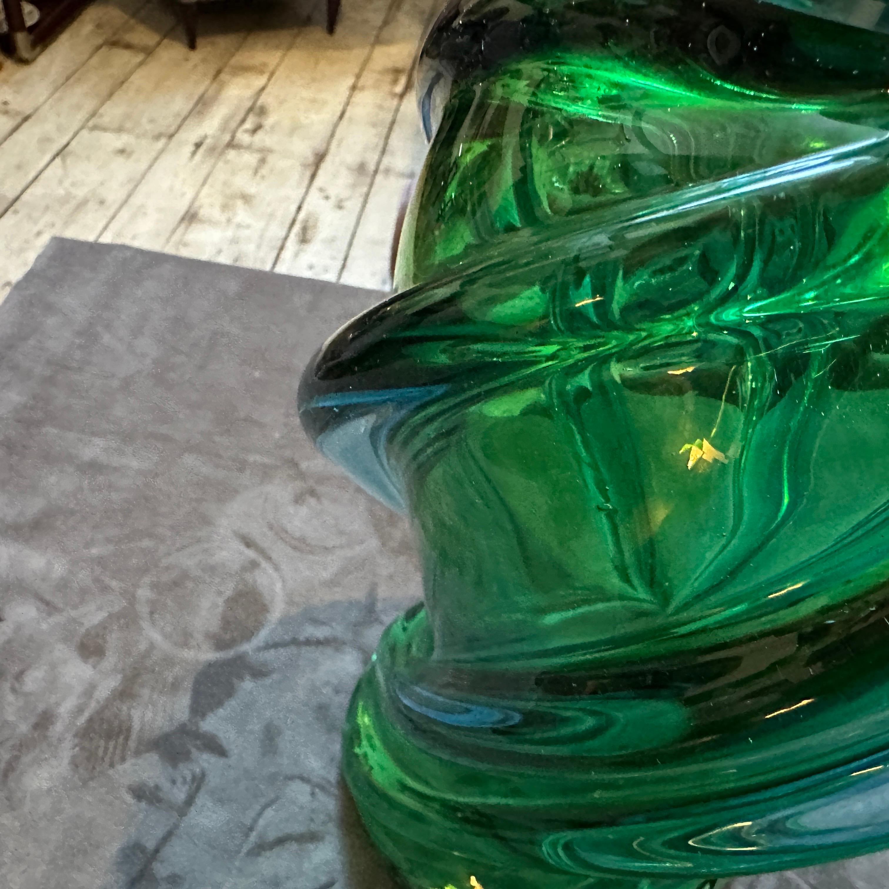 This spectacular 1960s Murano glass vase, attributed to the Seguso Vetri d'Arte factory, is a masterful example of mid-century Italian design. The piece showcases a vibrant swirl of emerald green glass with subtle hints of blue, meticulously