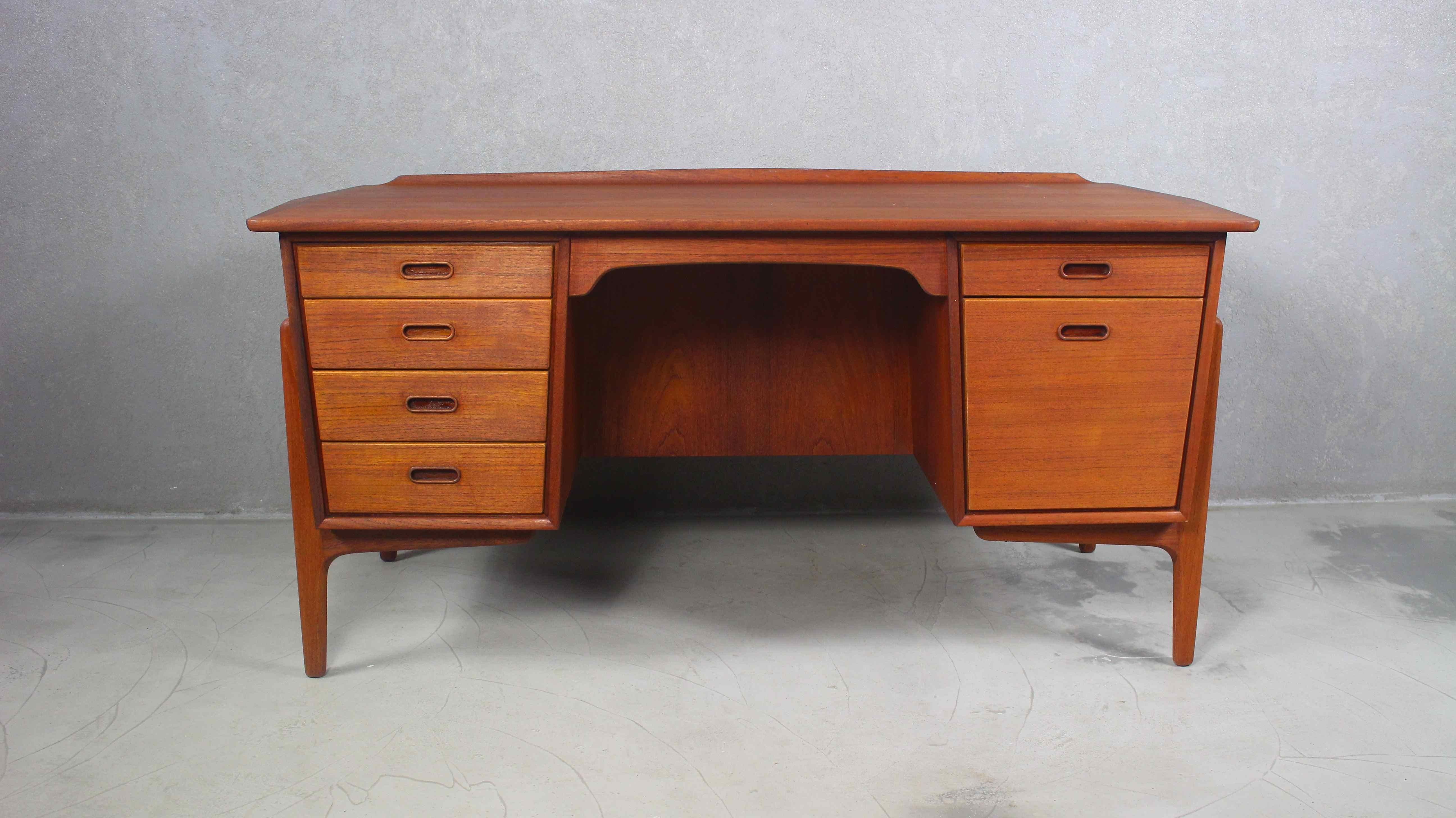 This teak writing desk was designed by Svend Aage Madsen for Sigurd Hansen, Denmark 1960s.
It features four drawers on the left side and one drawer and a cabinet on the right side.
On the backside is a large cabinet with a shelf which makes it