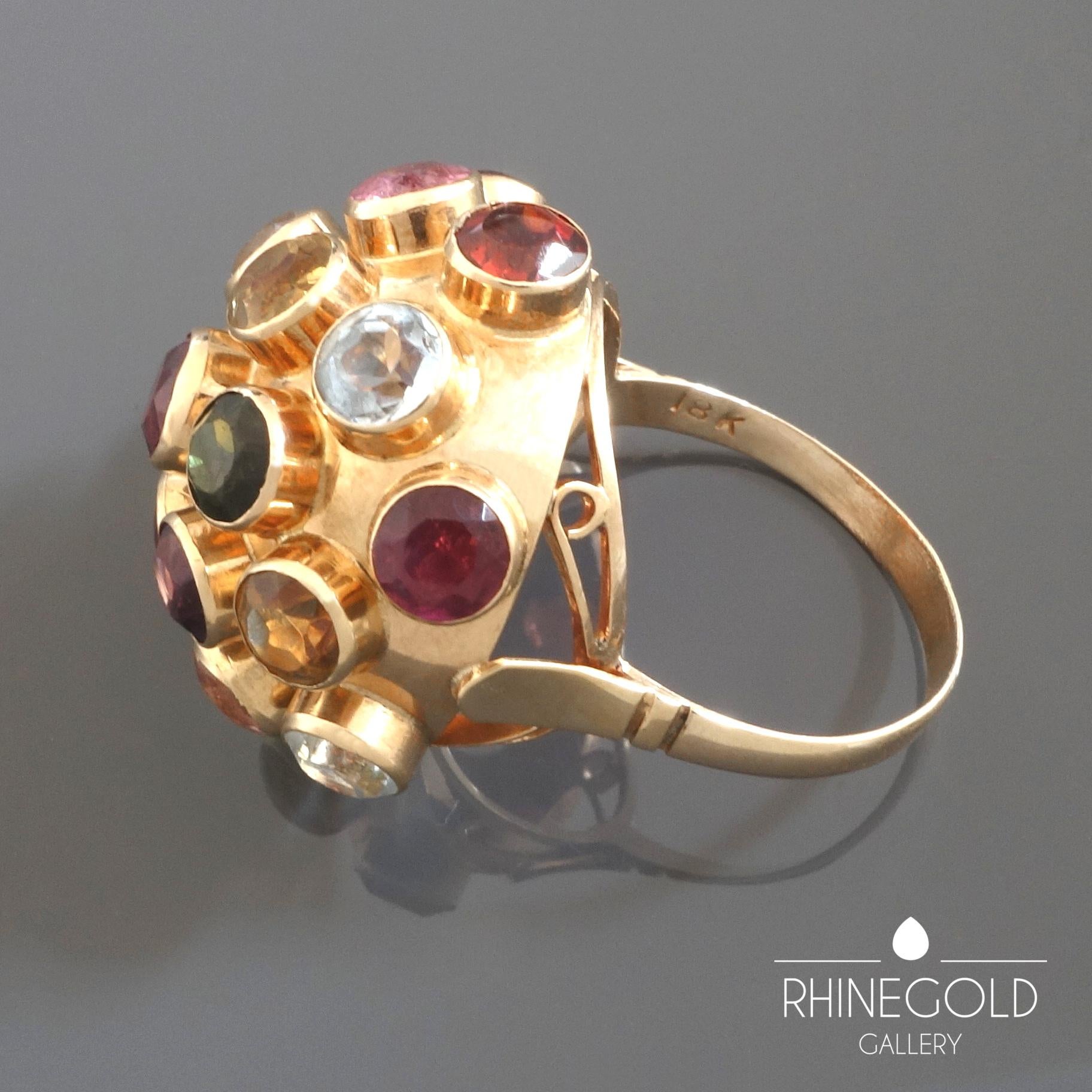 1960s Midcentury Modernist Multi Stone Gold Sputnik Ring
18k rose gold, various precious stones (amethyst, citrine, tourmaline, garnet, aquamarine, etc.)
Ring head: Ø 2.4 cm (approx. 15/16”)
Ring size: Ø 17.5 mm = EU 55.1 / US 7 1/4 / ASIA