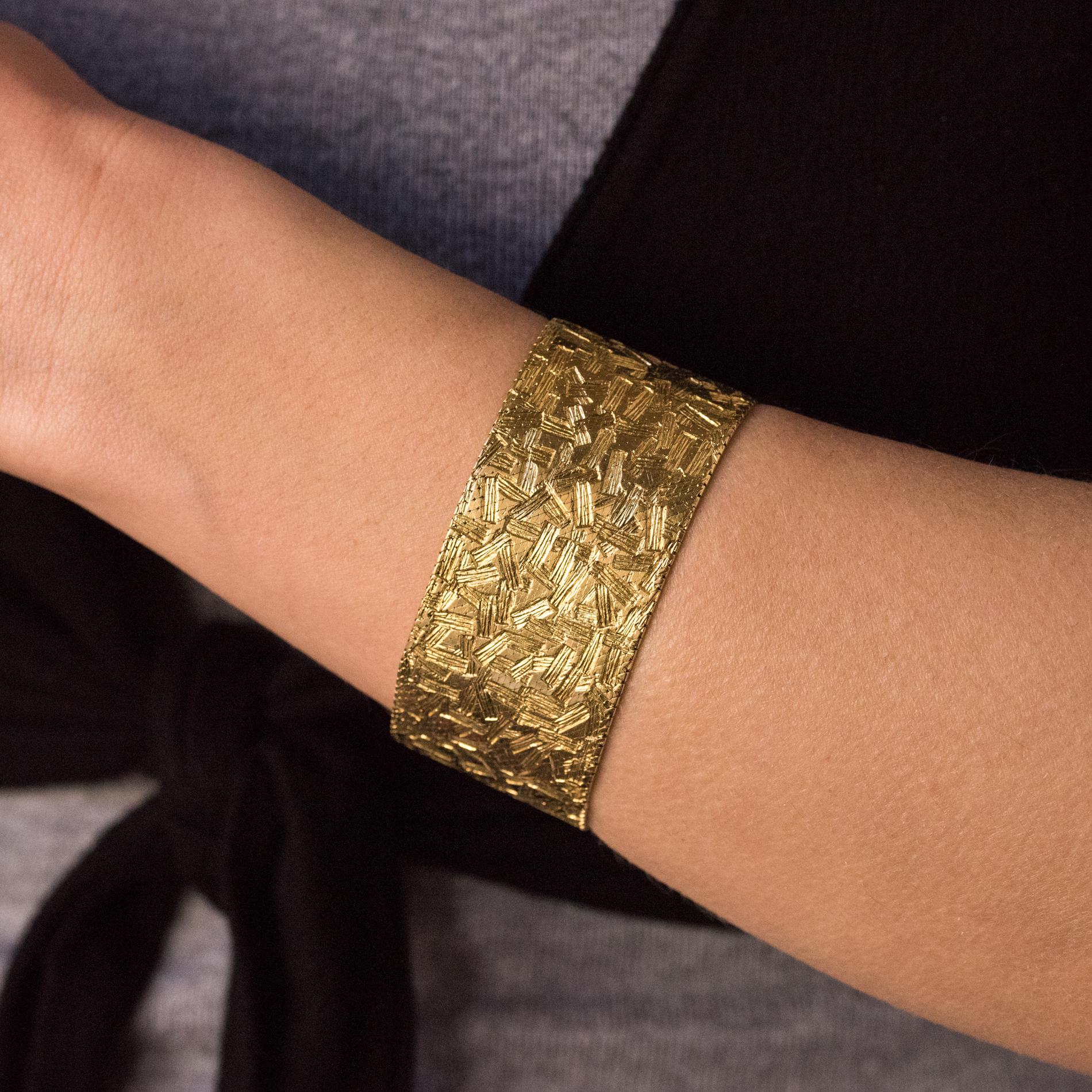 Armband aus 18 Karat Gelb- und Weißgold, mit Rüsselpunze.
Dieses schöne Retro-Armband ist aus einem gemusterten Mailänder Stoffgeflecht gefertigt. Der Verschluss ist ein Ratschenverschluss mit 2 Sicherheits-