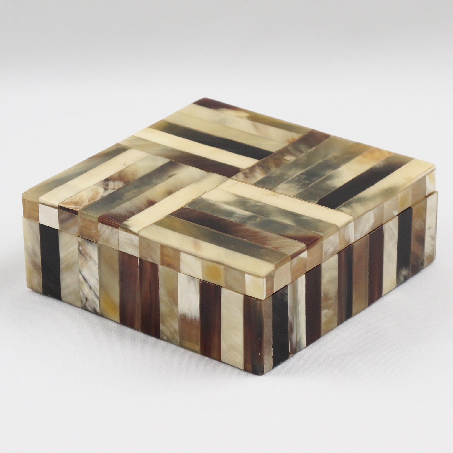 Elegant 1960s lidded decorative box in real horn. Square shape with solid mahogany wood interior and geometric horn marquetry patchwork. Lovely art work with multi-toned real horn. 
Measurements: 4.94 in. wide (12.5 cm) x 4.94 in. deep (12.5 cm) x