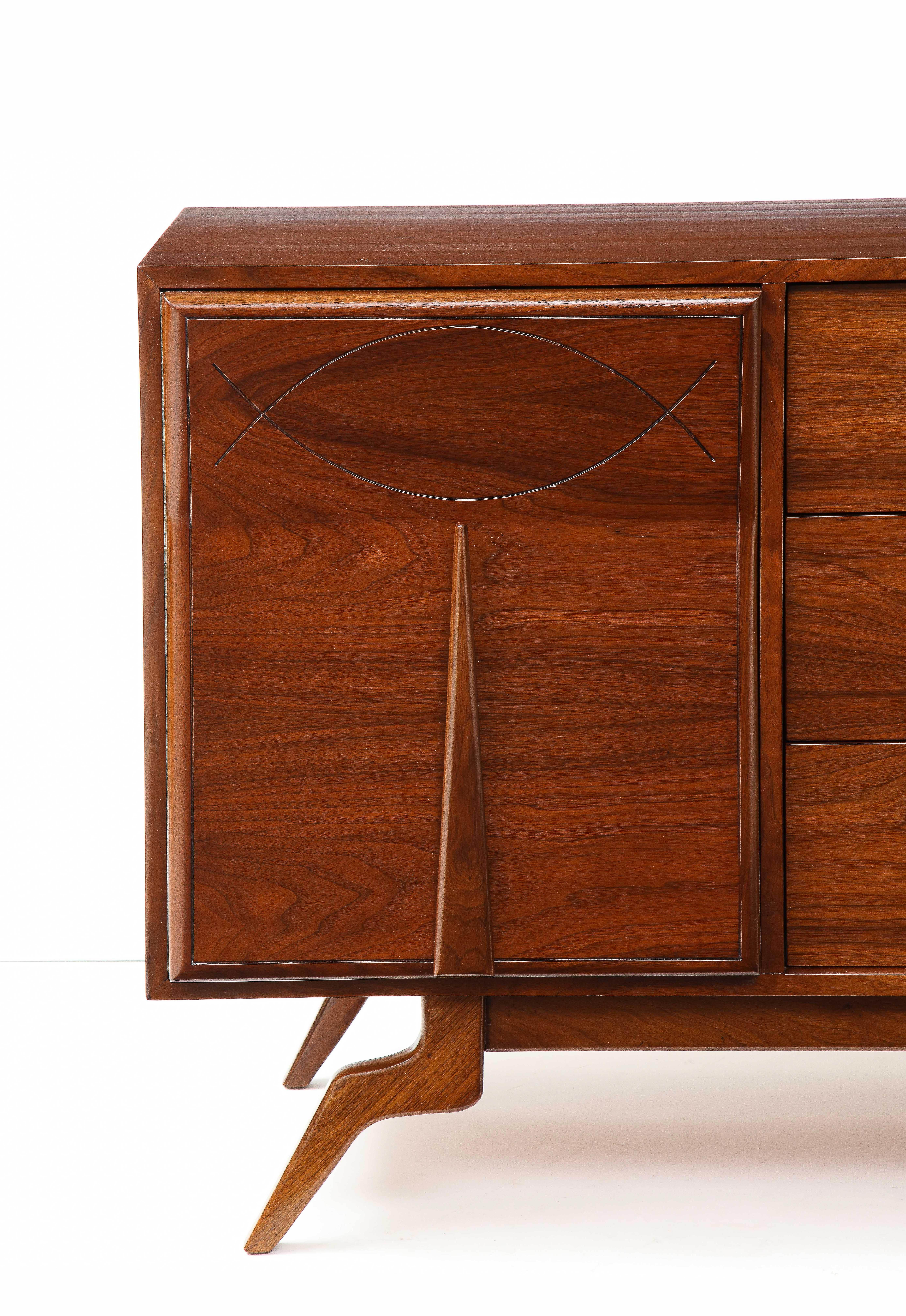 Stunning 1960's Mid-Century Modern sculptural walnut dresser credenza, with fish motif detail and wood and brass long handles, fully restored.
