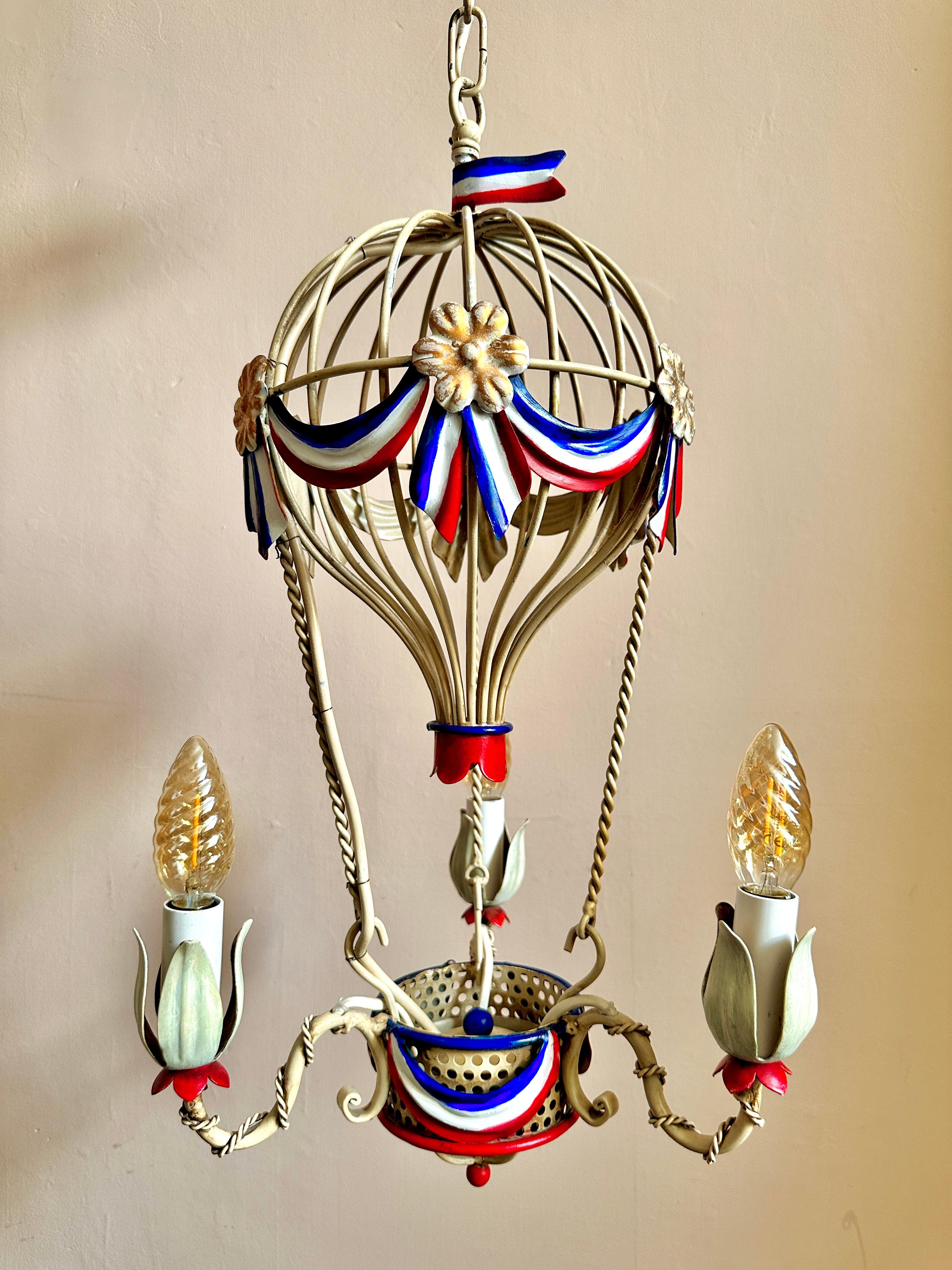 1960s Montgolfier tole chandelier (two available).

Gorgeous hand-painted, three-arm Italian ceiling light based on the Montgolfier Brothers' hot-air balloon design. Decorated in the colours of the tricolore with gilt rosettes. In excellent