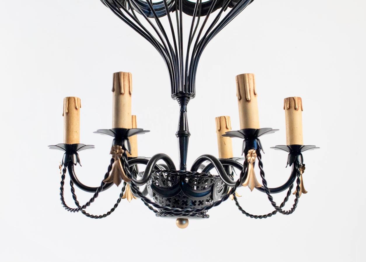 Composed of black wrought iron wire forming a balloon decorated with a central garland enhanced with flowers and golden crest.
The ball is connected to a black openwork wrought iron basket decorated on the bottom of a gilded brass ball.
 Inside the