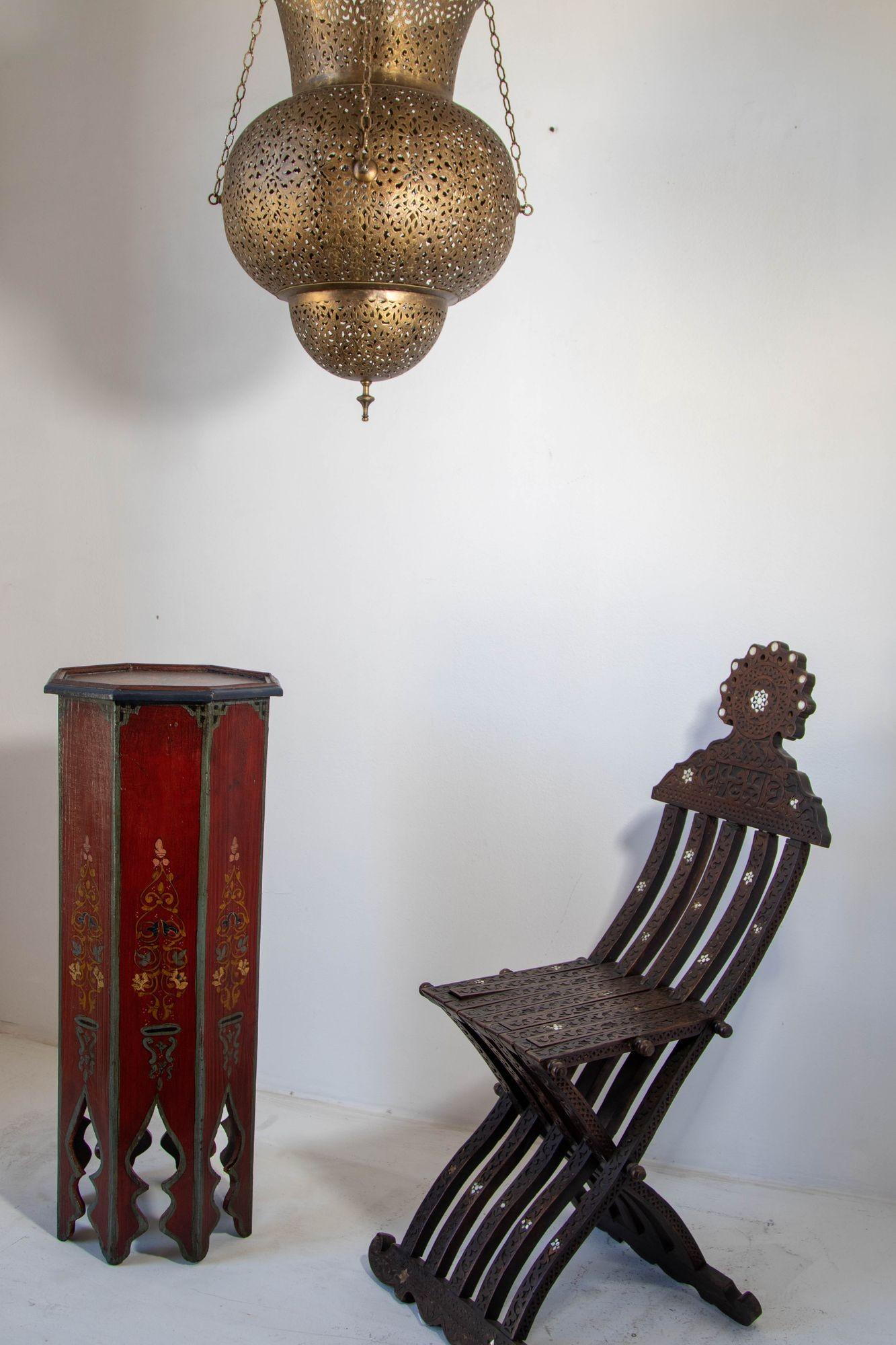 Tavolo marocchino vintage con piedistallo, dipinto a mano su uno sfondo marrone scuro con disegni floreali e geometrici nei colori blu e giallo.
Tavolo marocchino in design policromo con archi moreschi sulla base del tavolo di forma ottagonale.
Arte