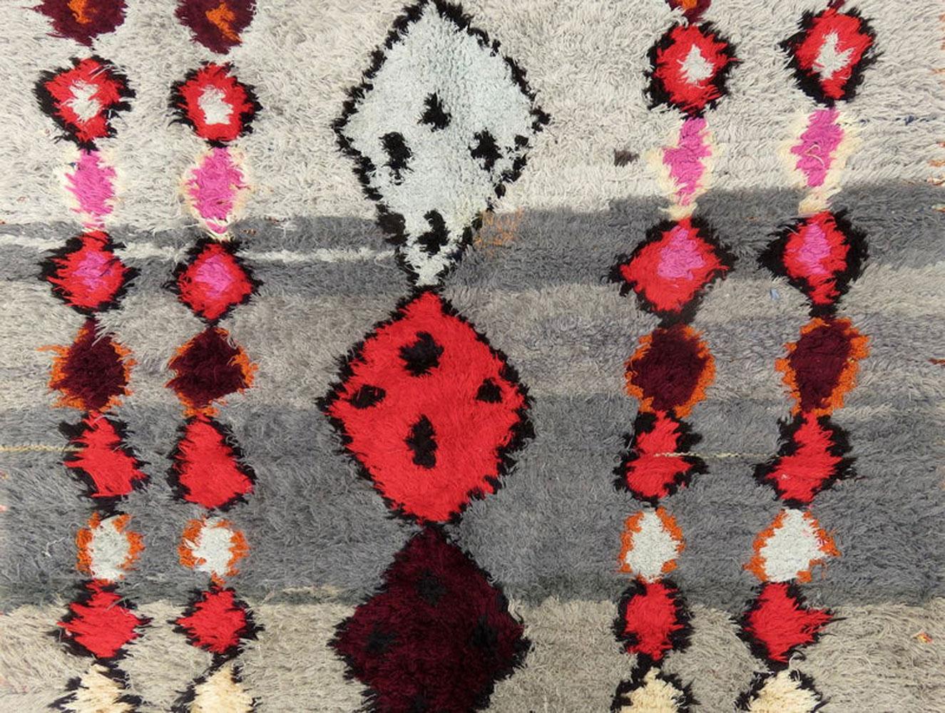 Midcentury Ourika ombre rug handwoven with shades of grey, pink, red, garnet and black colored wool in an elaborate abstract pattern of Berber symbols.
Dimensions: 3'9 x 7'8
