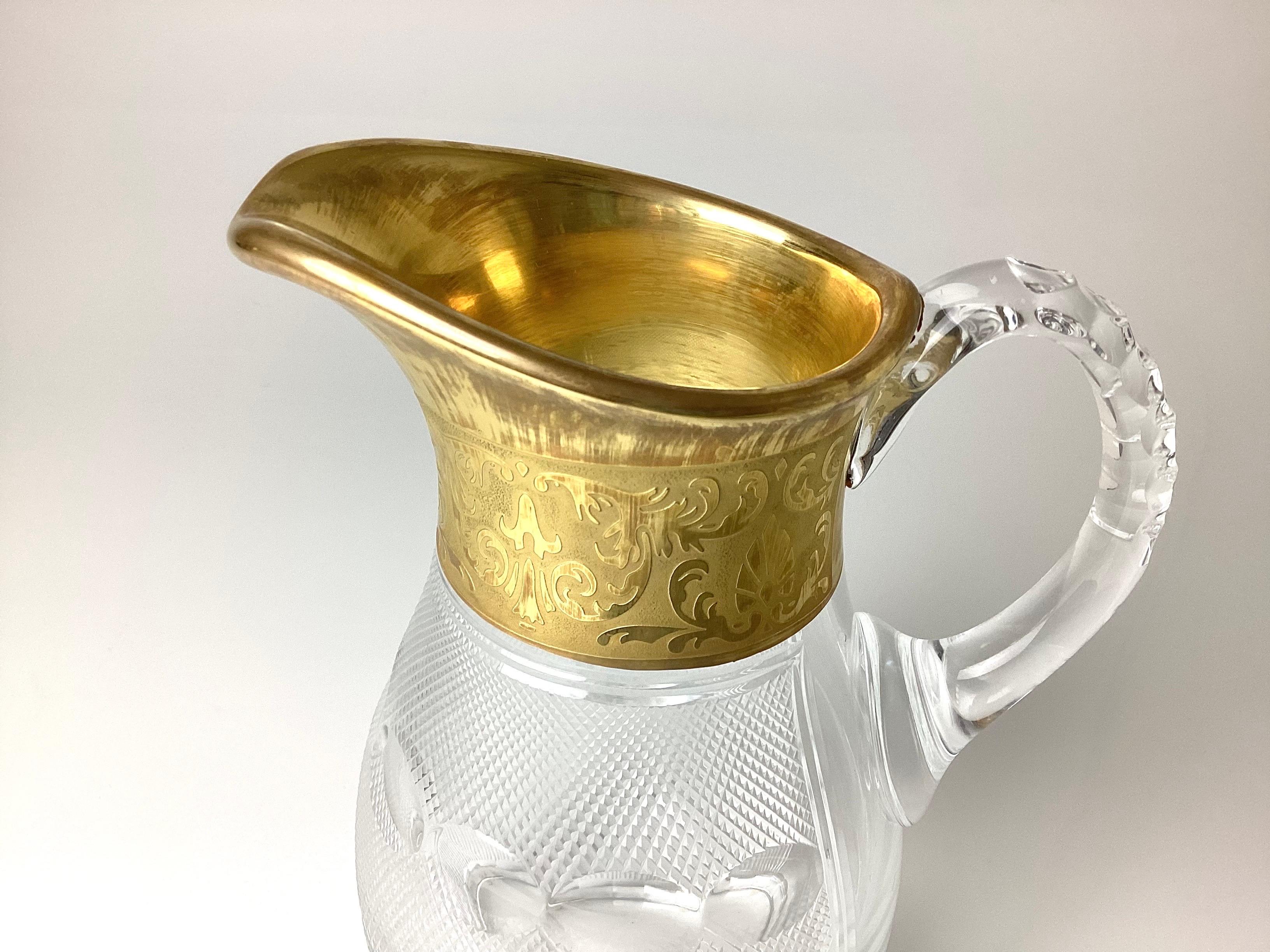 Moser Cut Glass Water Pitcher with Gold Trim. 9 inches tall by 7 inches wide handle to spout 5 inches in diameter. Mosier logo on the bottom and clear tag on the front bottom edge. Wonderful condition with no chips to the crystal or gold loss. Pads