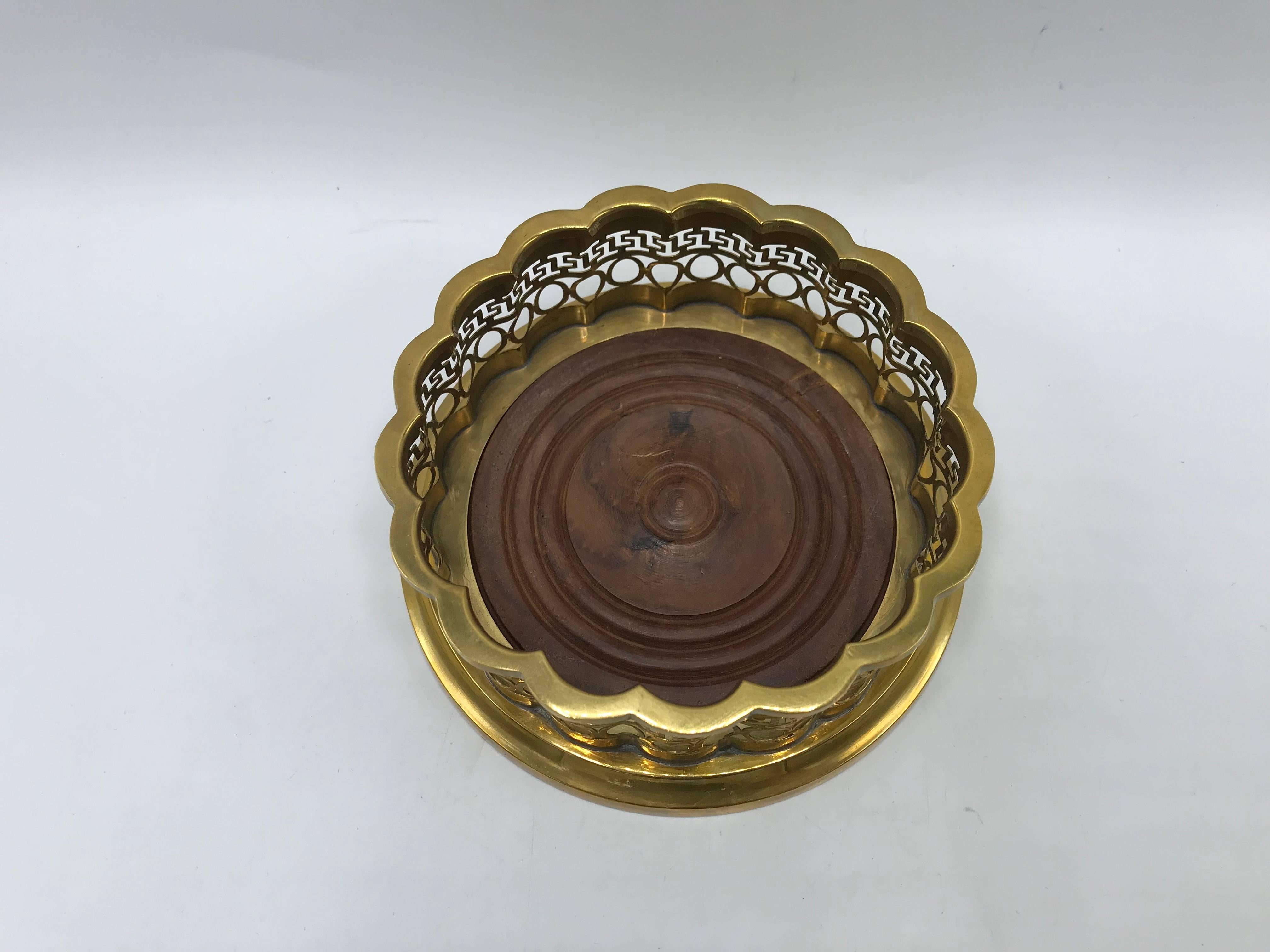 Offered is a stunning, 1960s Mottahedeh brass and walnut wine bottle coaster from the Historic Natchez Foundation collection. The piece has a beautiful, pierced brass cuff with a Greek key motif. Marked on underside with brass plaque, see last photo.