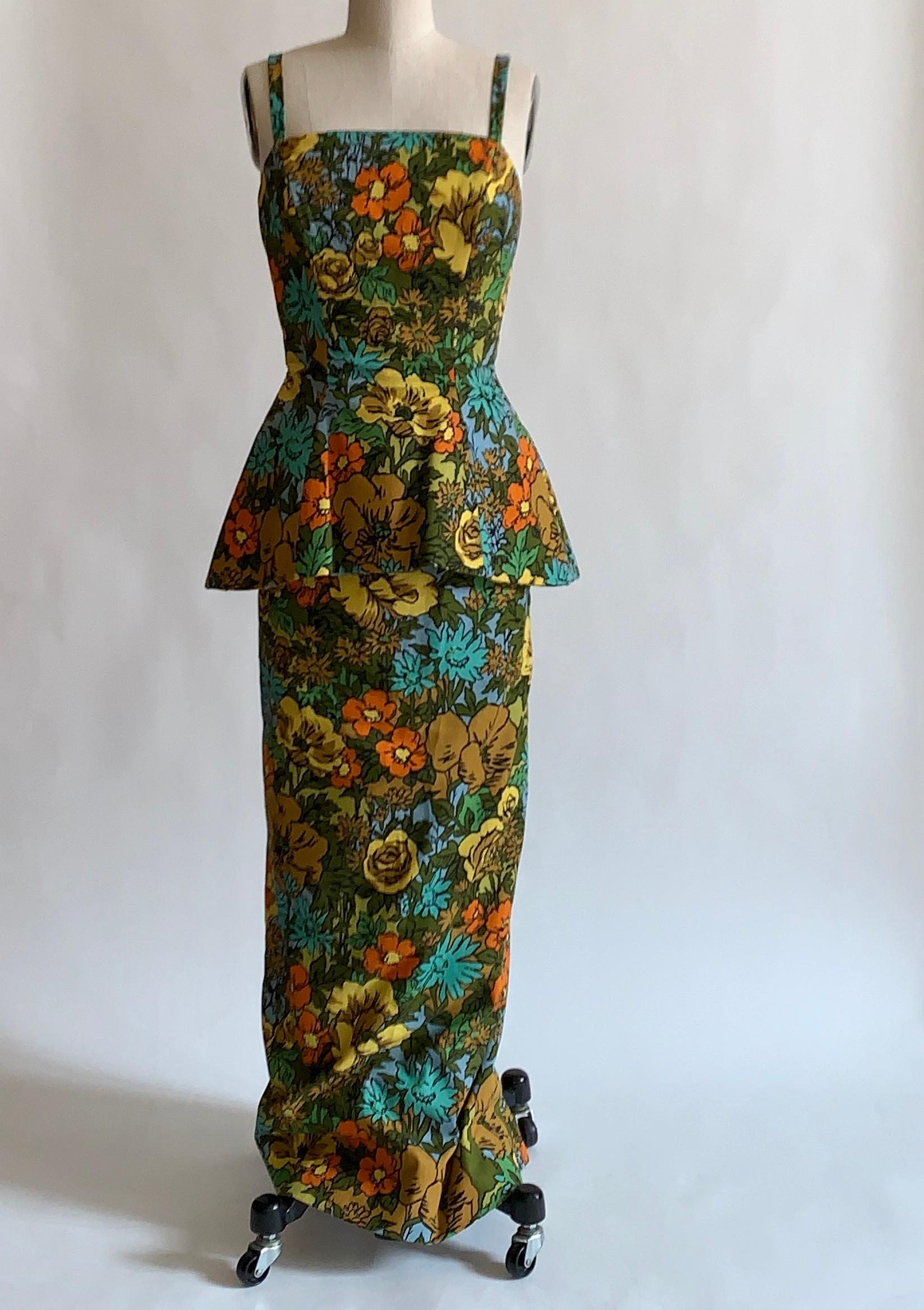 Stunning 1960s vintage Mr. Blackwell Custom floral print dress in vibrant shades of yellow, orange, brown, blue, and green. Peplum waist that feels like it must be enforced with horsehair.  Slit at center back. Two zips at back, with small bow