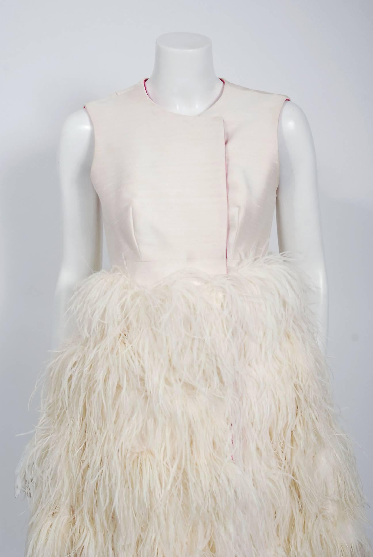 Exquisite 1960's ivory-creme textured silk cocktail from the famous Mr. Blackwell custom label. To this chic show-stopper, he adds rows of genuine ostrich feathers which add so much depth and texture. The sleeveless bodice has hidden side snaps with