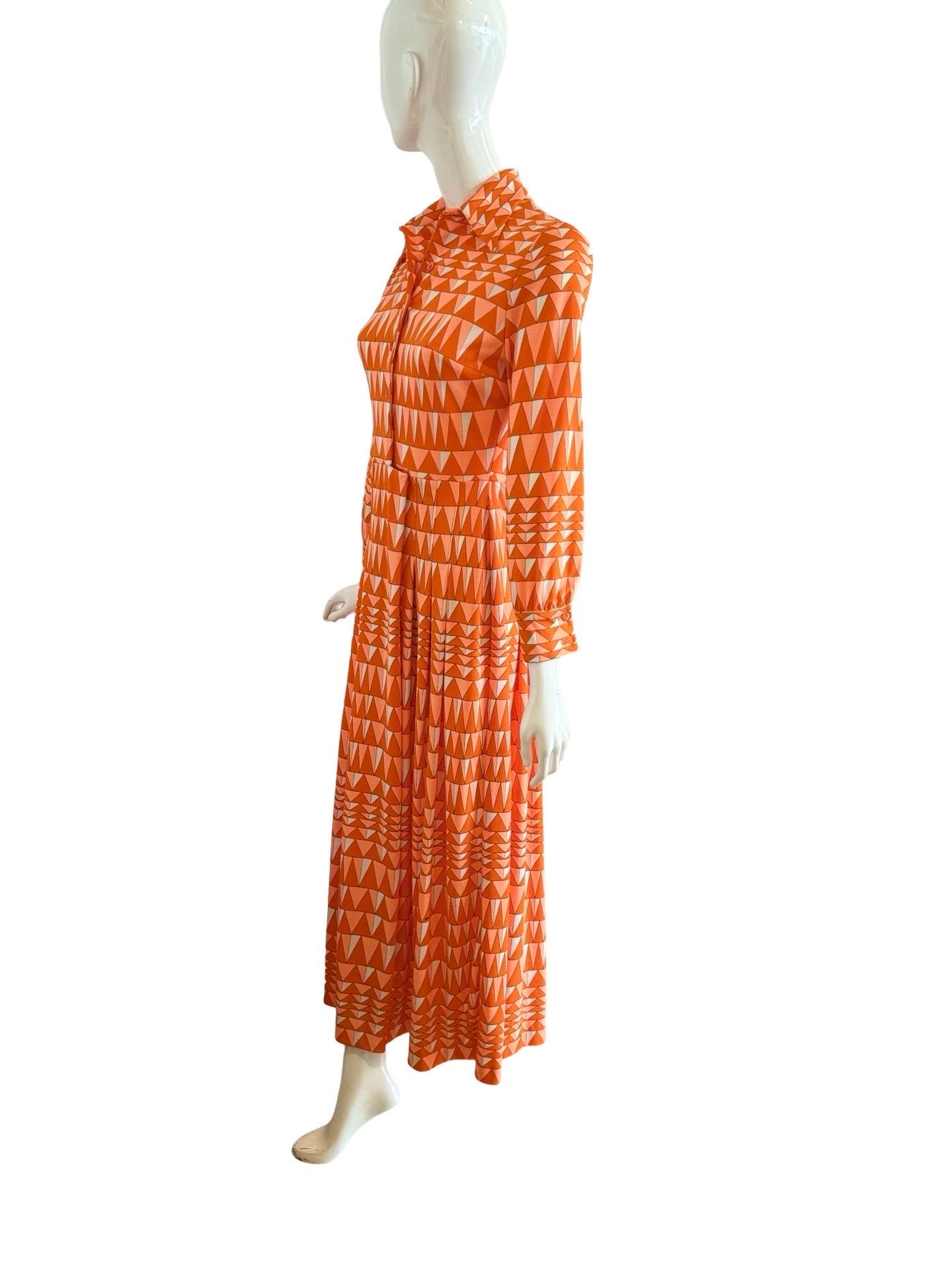 Incredible 1960s bright orange Mr. Dino maxi dress in an all over print of geometric triangles in two shades of bright orange and contrasting white.  The fabric is a polyester, which was typical of Mr. Dino dresses in that era.

The top portion of