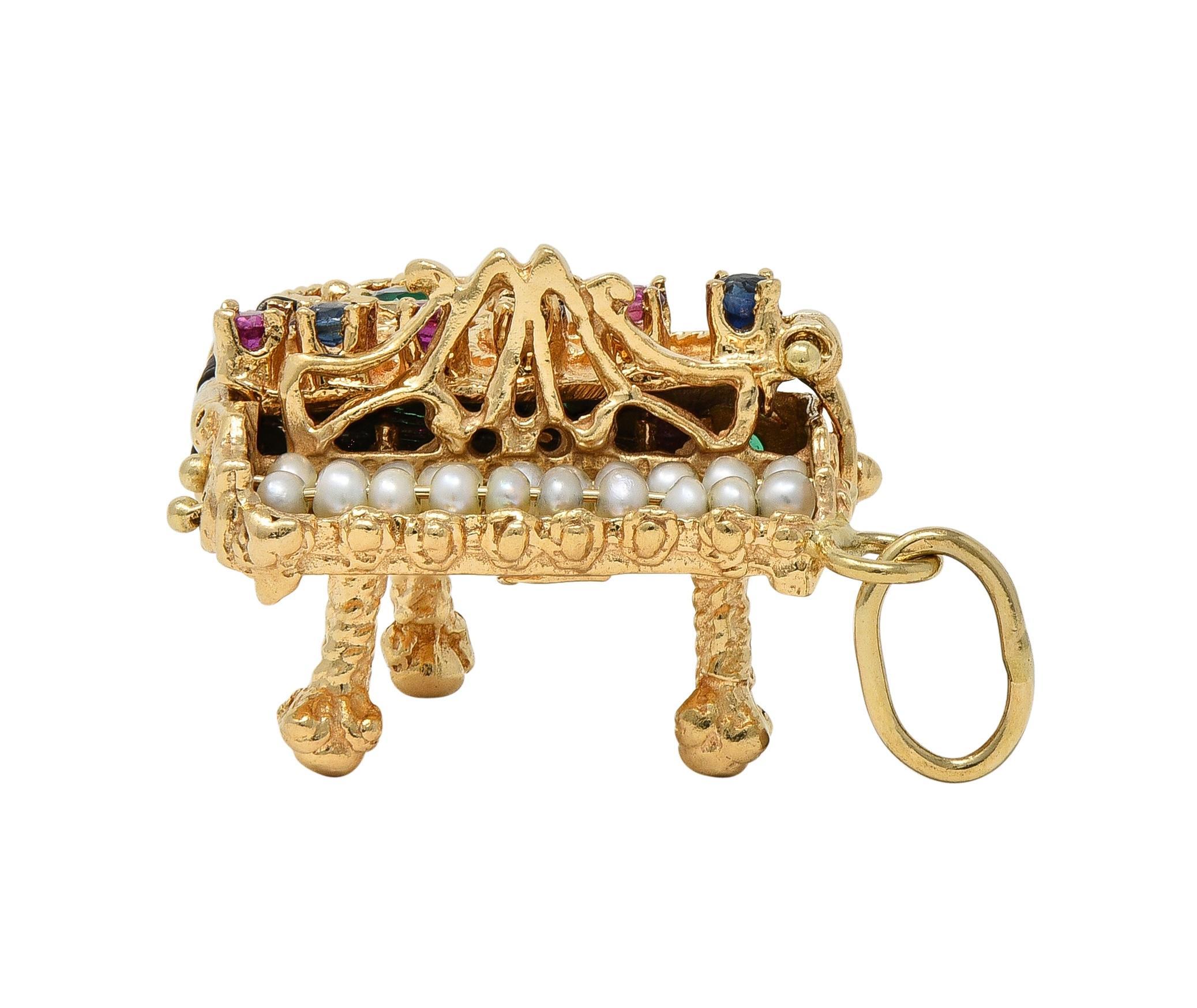 Designed as a highly dimensional grand piano with grooved texture and scrolling filigree throughout
Featuring hinged lid that opens to reveal gold strings and closes with hinged clasp closure
Accented by round cut rubies, sapphires, and chrysoprase