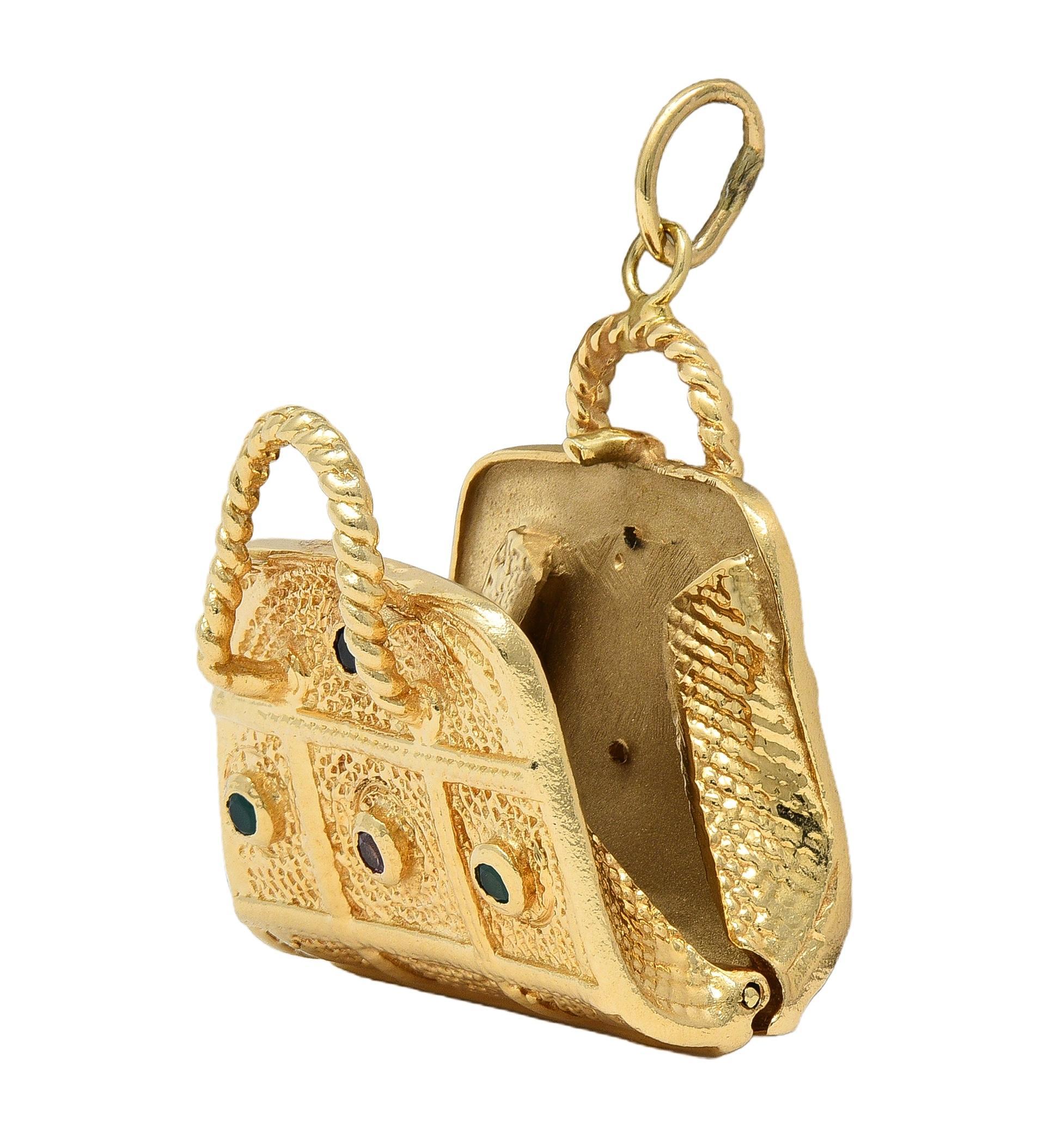 Designed as a dimensional purse with grooved stipple texture and twisted rope handles
Opens on a hinge to reveal compartment inside purse that clicks shut
Accented by bezel set 1.5 mm round cut sapphires and chrysoprase
Sapphires are transparent