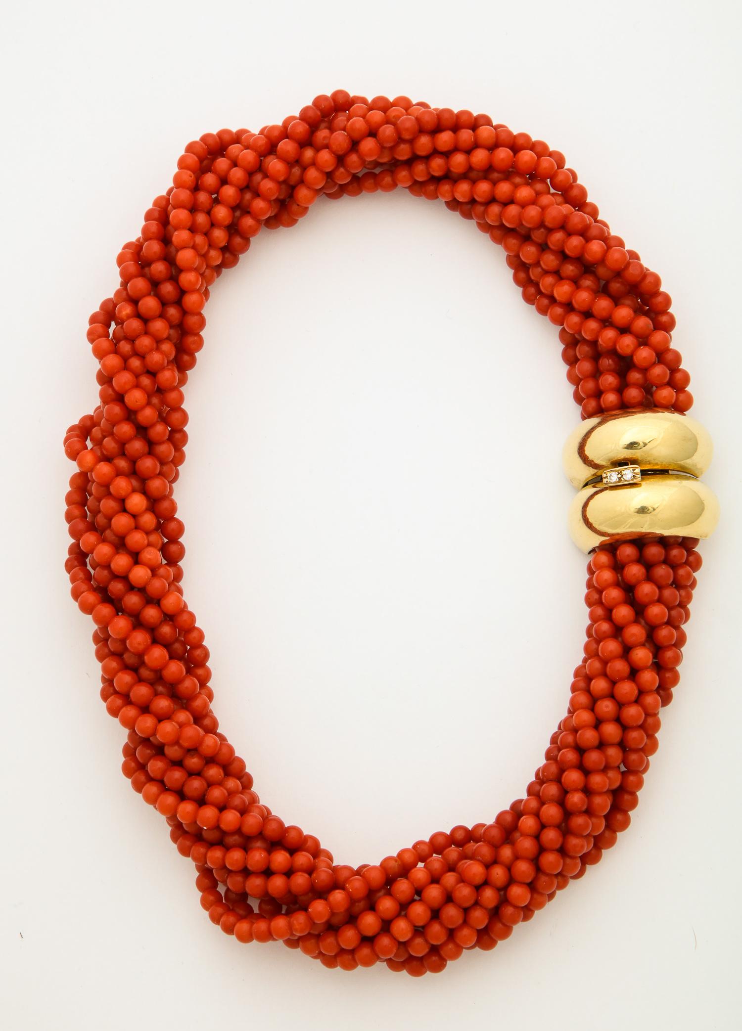 One Ladies Torsade Twist Necklace Consisting Of Eleven Strands Of Deep Orange Color Coral Beads.Beautifully Finished With An 18kt High Polish Yellow Gold Clasp Embellished With Teo Full Cut Diamonds. Created In The United States Of America In The