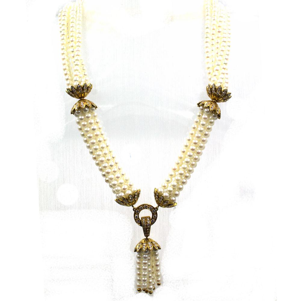 This beautiful tassel pearl and diamond necklace is circa 1960's. The six strands of pearls are gathered with gold diamond stations and features a central pearl and gold tassel. The stations are crafted in 18 karat yellow gold and feature