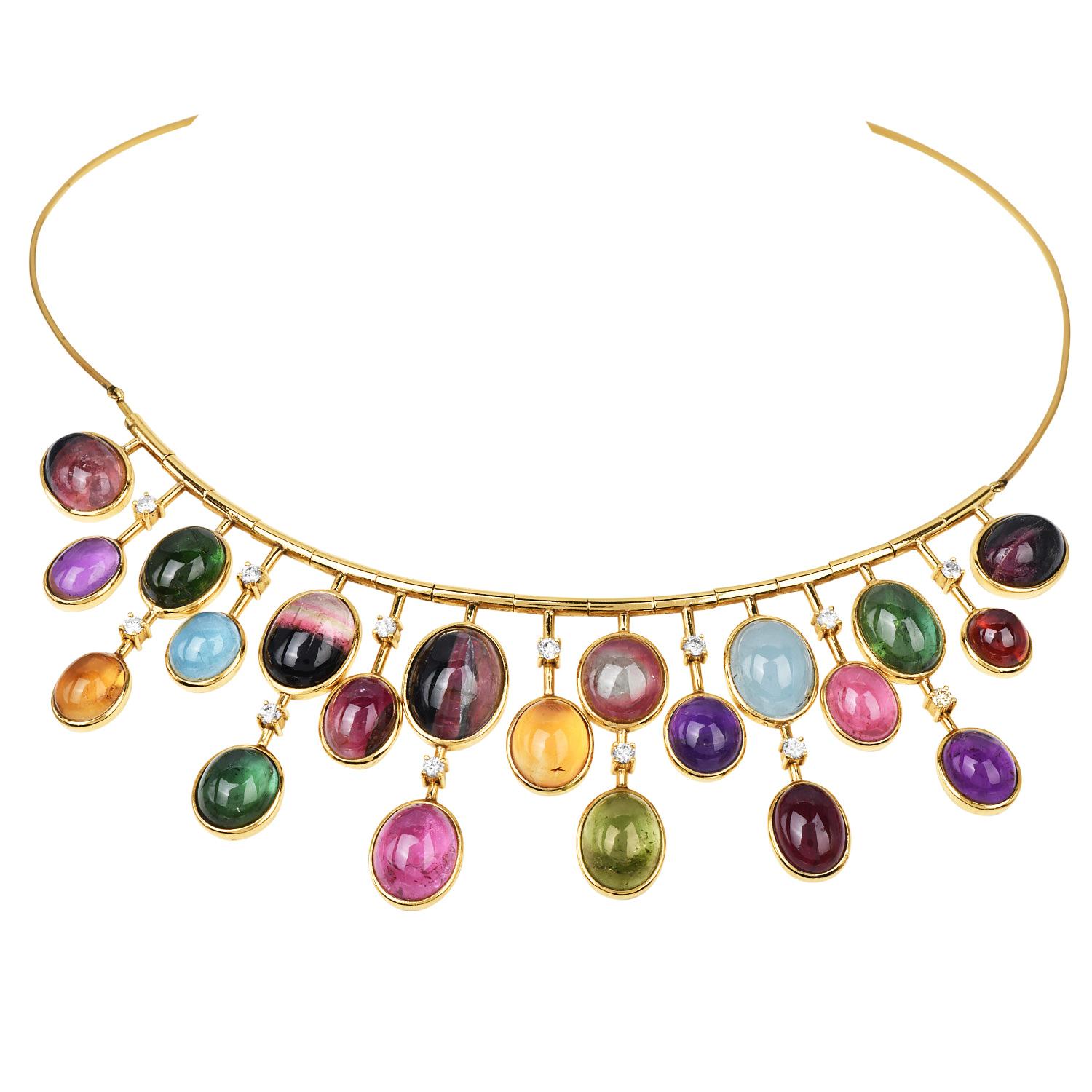 This statement necklace is crafted in rich 18K yellow gold and adorned with a luxurious fringe of bezel-set tourmaline cabochons, each showcasing a unique hue, ranging from vibrant greens and pinks to rich purples and ocean blues. The graduated