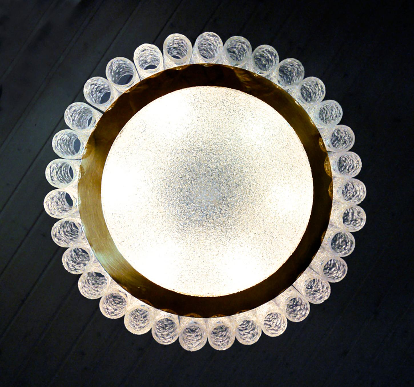 Elegant white laquered metal frame with in the center a structured glass disc, a brass ring and thirty two Murano glass tubes surrounding it all. Manufactured by Doria Lighting, Germany in the 1960s. 
 
Measurements: diameter approx. 18.12