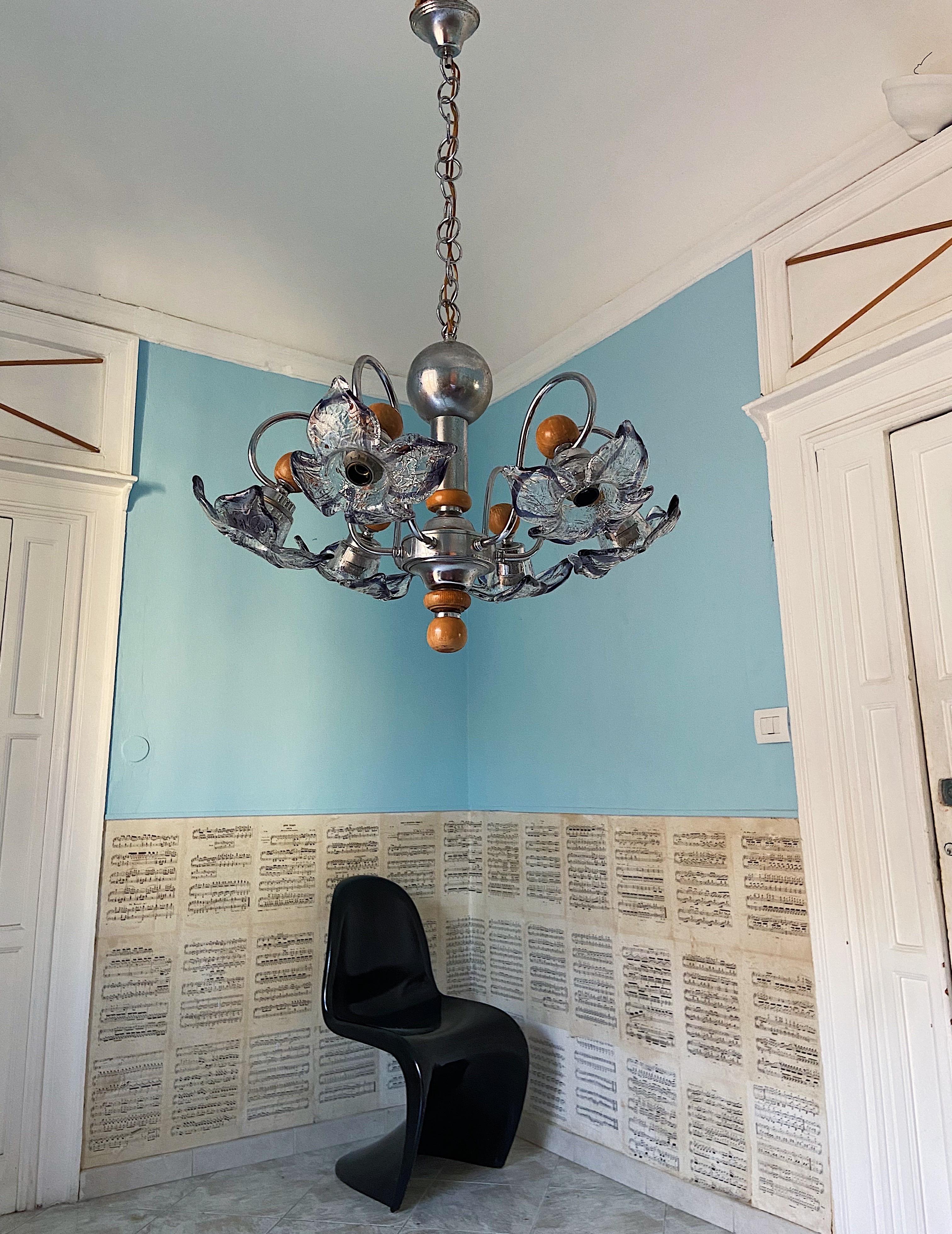 1960s Murano glass chandelier by Mazzega. Flower shaped glass that gradually transfers from transparent to a beautiful violet amber color. The metal base has details in pine wood. 6 light bulbs.

Details
Creator: Murano, Mazzega
Dimensions: