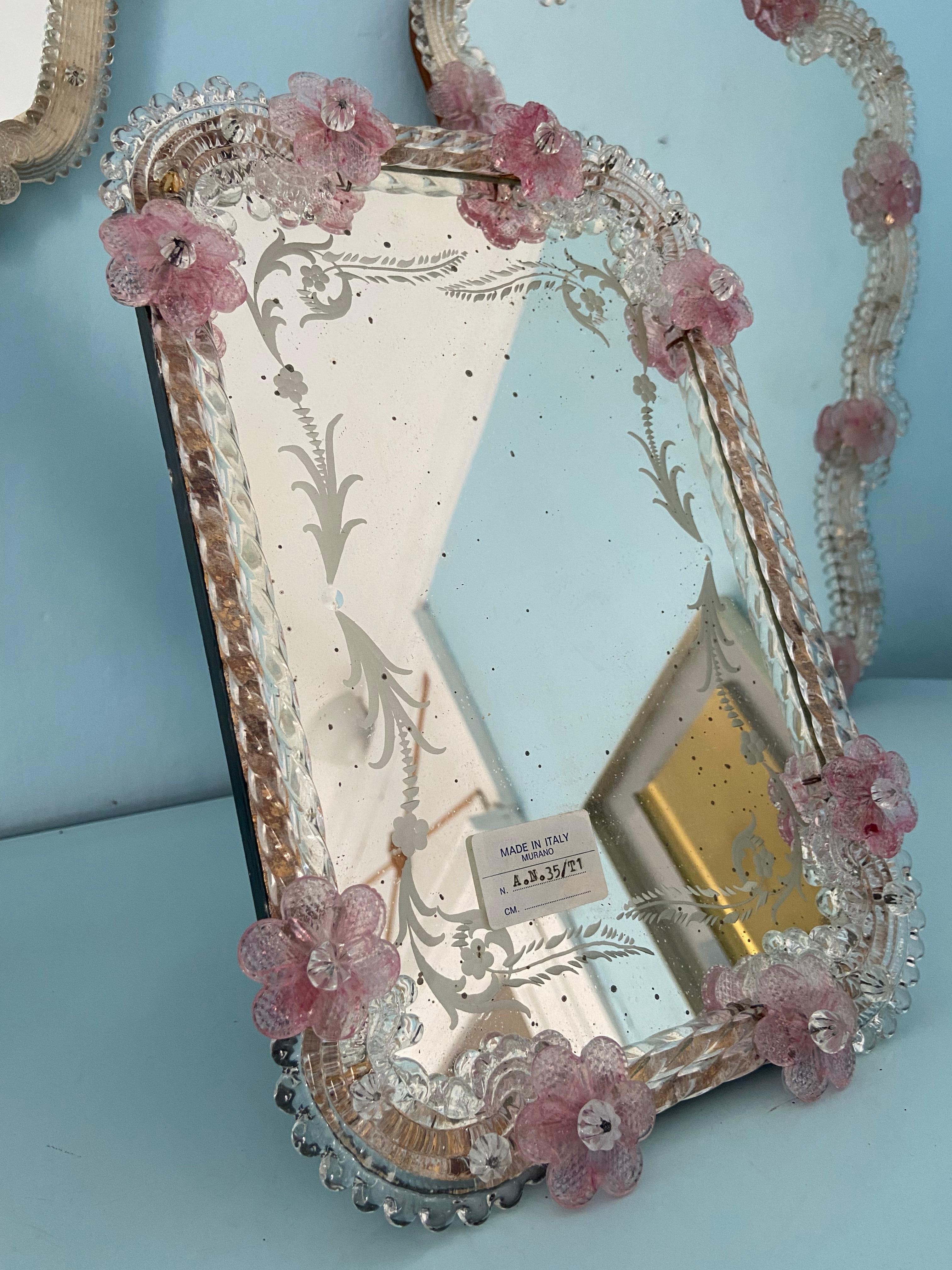 1960er Jahre Murano-Glas Spiegel mit rosa zarten Blumen. Das Spiegelglas selbst hat eine schöne Patina auf dem Glas. Der Spiegel ist zum Aufstellen gedacht. Wenn Sie es stattdessen aufhängen möchten, können Sie einen einfachen Haken an der