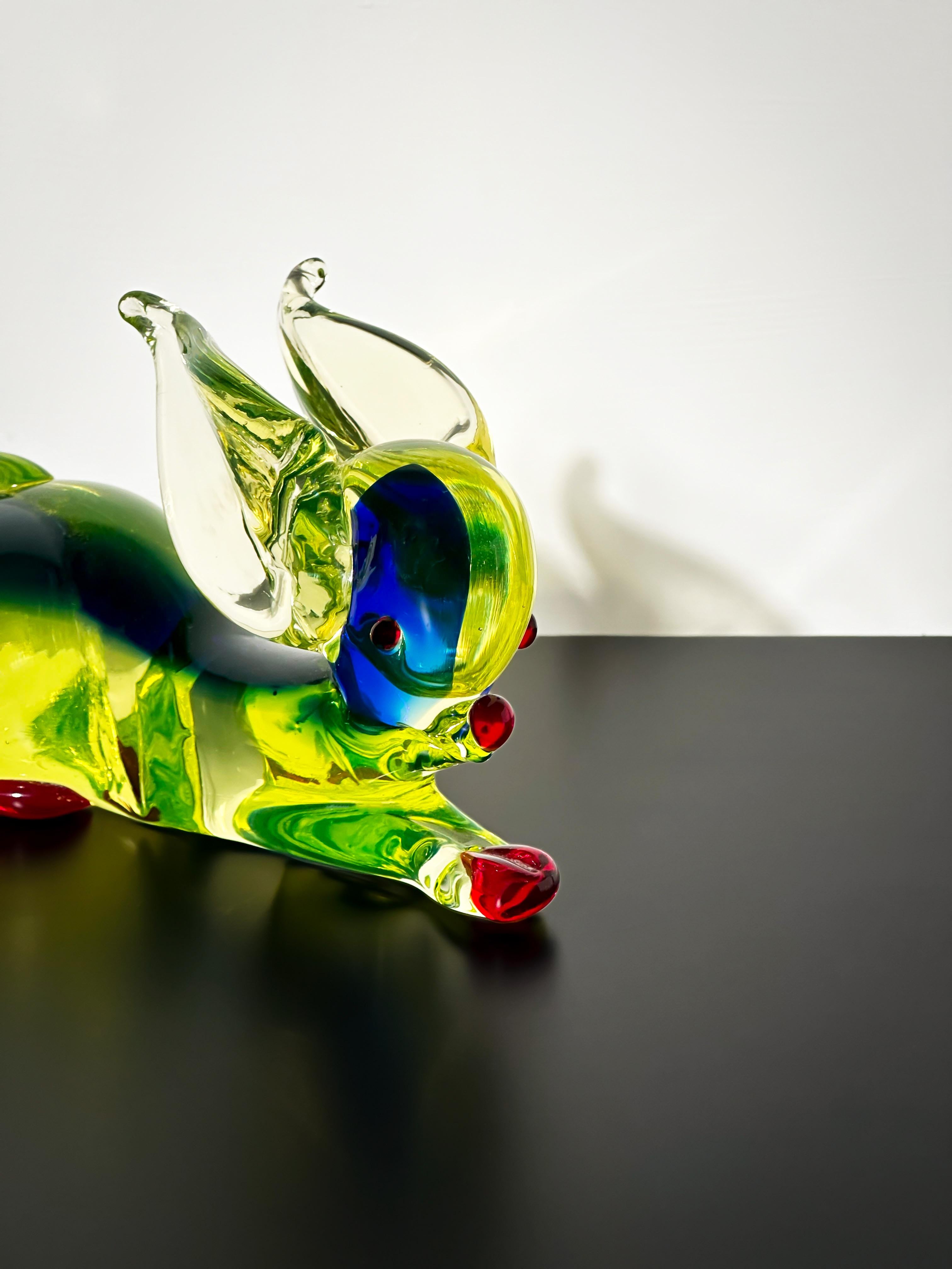A  Murano glass rabbit sculpture by Ferro & Lazzarini, exemplifying the playful, vibrant style of mid-century Italian glassmaking. Crafted from uranium glass, the piece displays a soft lime-green hue in daylight and emits a bright fluorescent glow