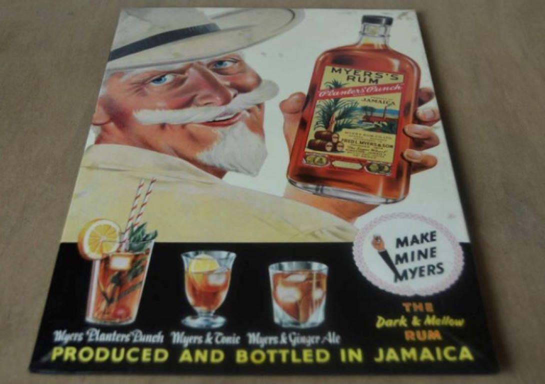 1960s vintage advertising sign for Myers Rum Jamaica.
Smiling very handsome man with blue eyes, hat, beard and moustache holding a bottle of Planters' Punch rum. This sign for Jamaican rum was made for the Belgian market - with still the tax stamp