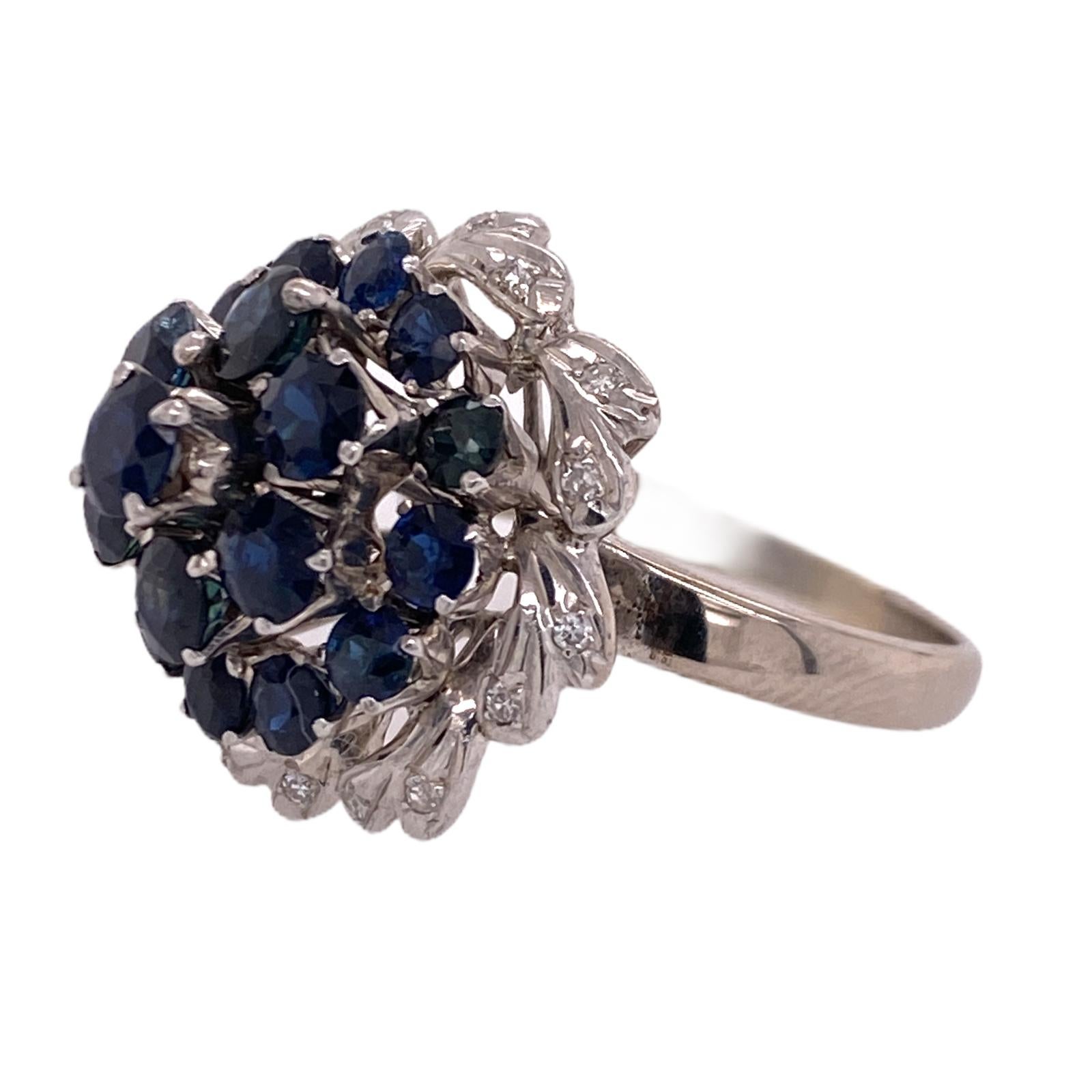 Fabulous 1960's blue sapphire diamond dome ring fashioned in 18 karat white gold. The ring features 19 natural blue sapphires weighing approximately 3.00 carat total weight. The diamonds are surrounded by 16 round brilliant cut diamonds weighing