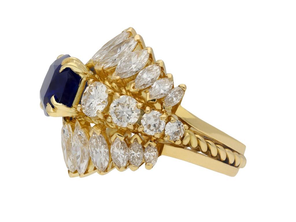 Natural Burmese sapphire and diamond ring. Set centrally with one cushion shape old cut natural unenhanced Burmese sapphire in an open back four claw setting with an approximate weight of 5.36 carats, flanked by eight round brilliant cut diamonds in