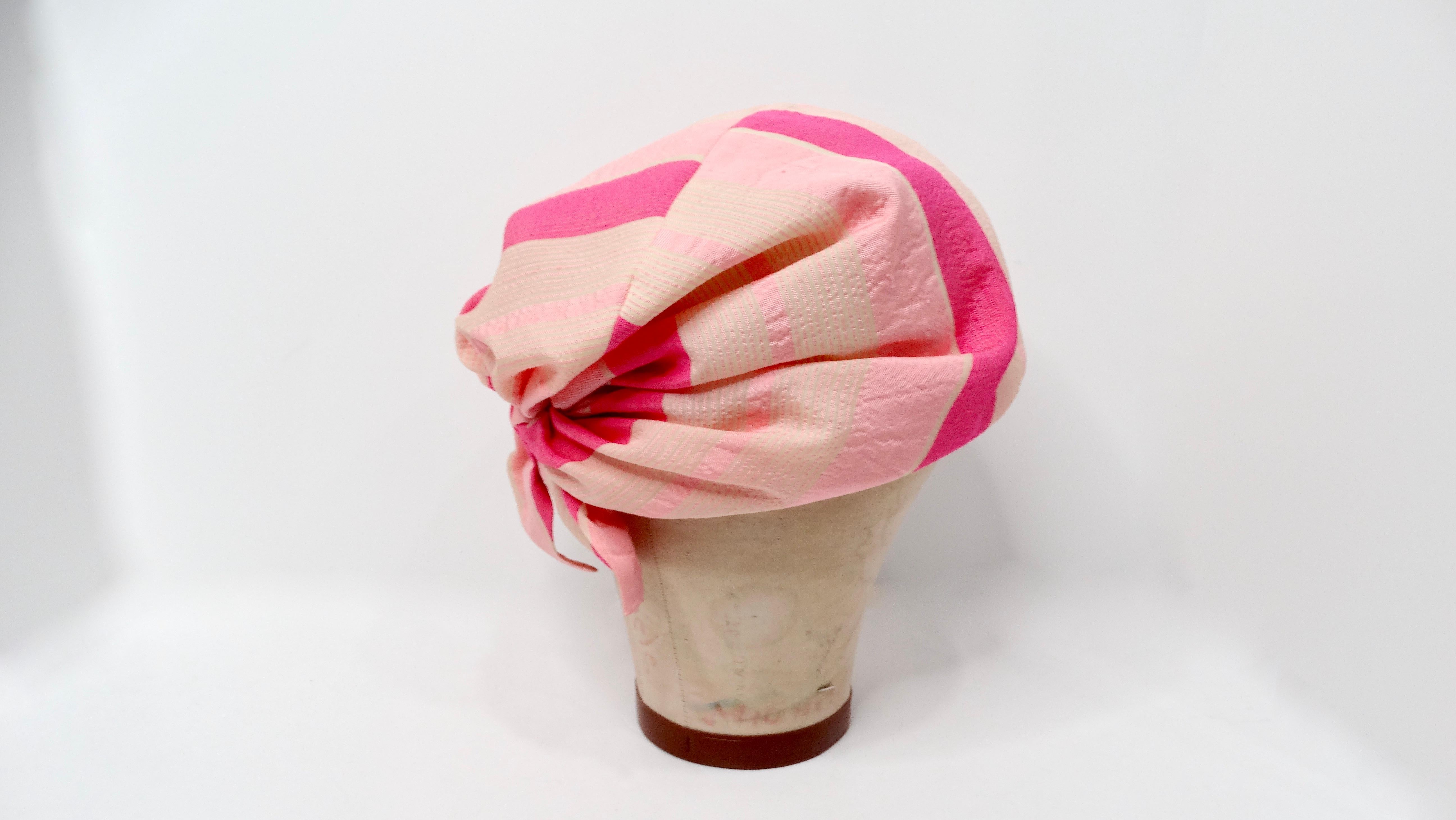 The 1960s Neiman Marcus Custom Pink Stripe Print Silk Turban is a stunning piece that embodies the elegance and glamour of its era. Crafted from a silk blend, this turban features soft pink stripes that create a playful yet sophisticated look. It